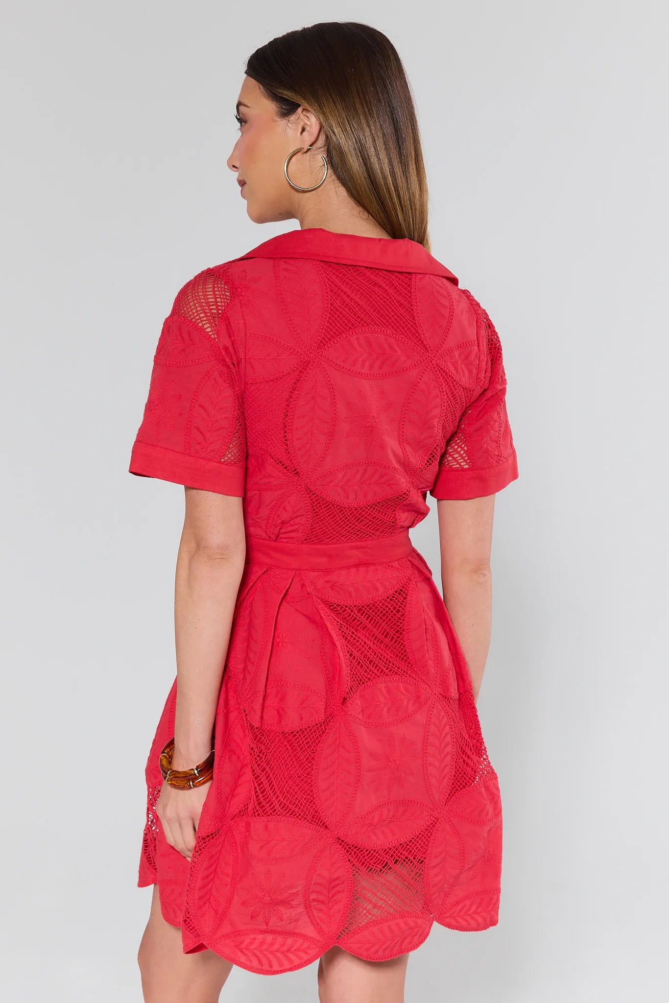 Red dress with geometric patterns worn by a person on a white background