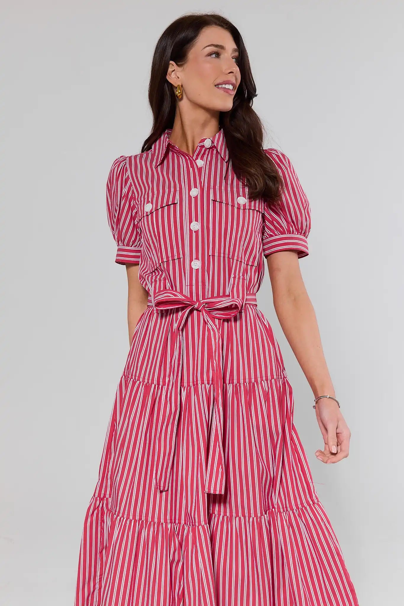 Woman wearing a red and white striped dress against a plain background