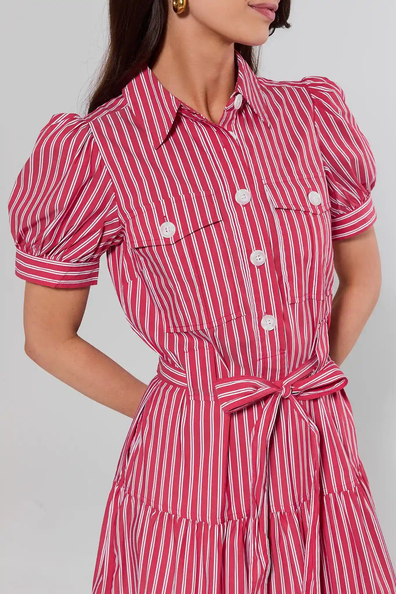 close up Woman wearing a red and white striped dress with puff sleeves on a plain background