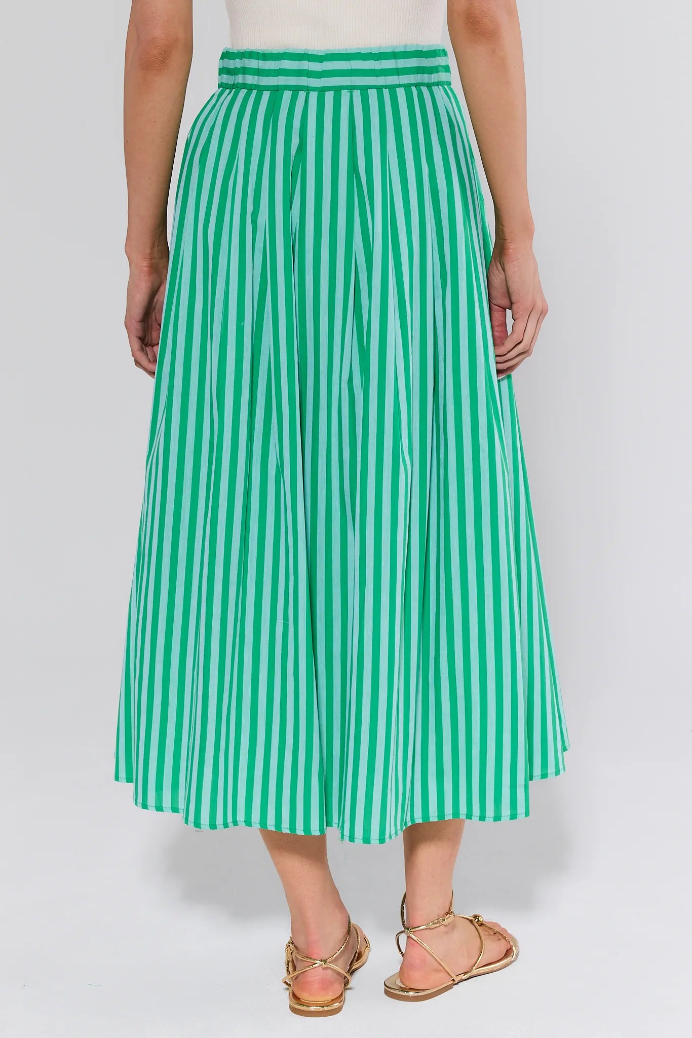 person wearing green and green stripe skirt on white background