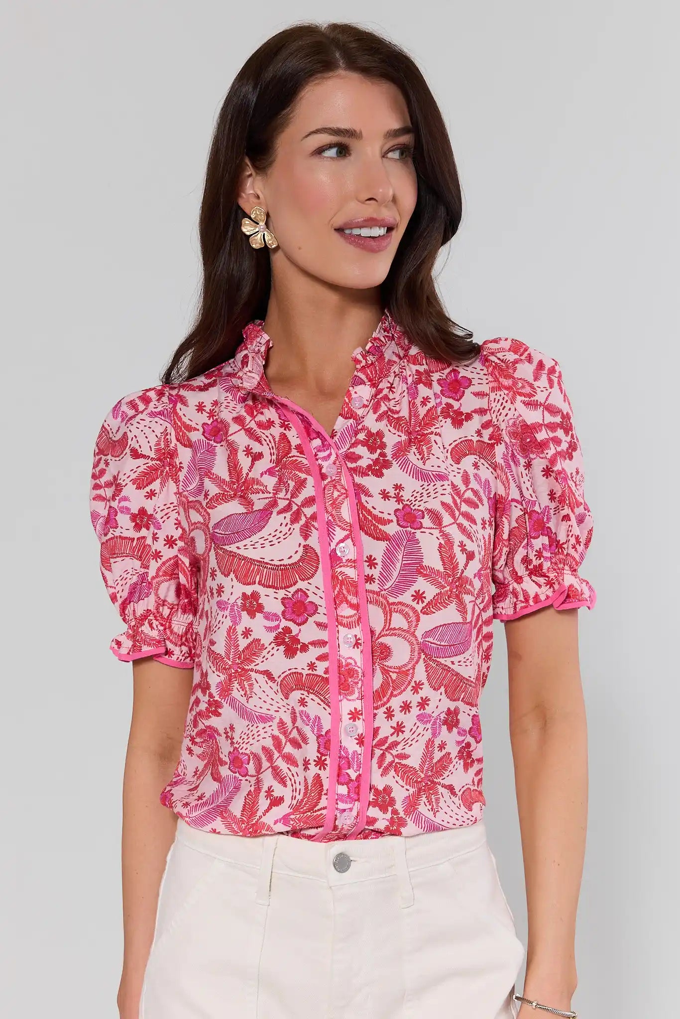 Woman wearing a pink floral blouse against a gray background
