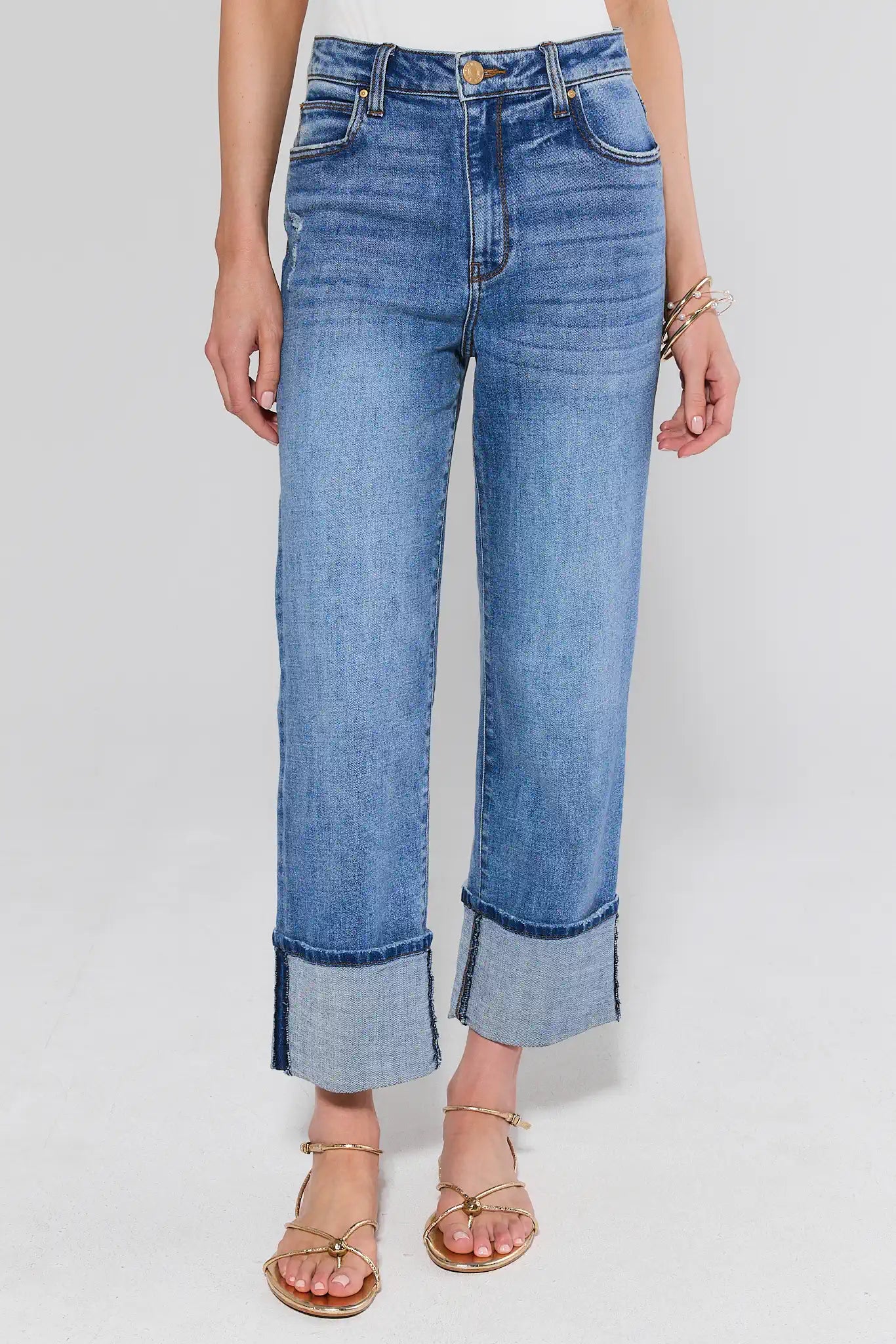 Person wearing blue jeans on a plain background