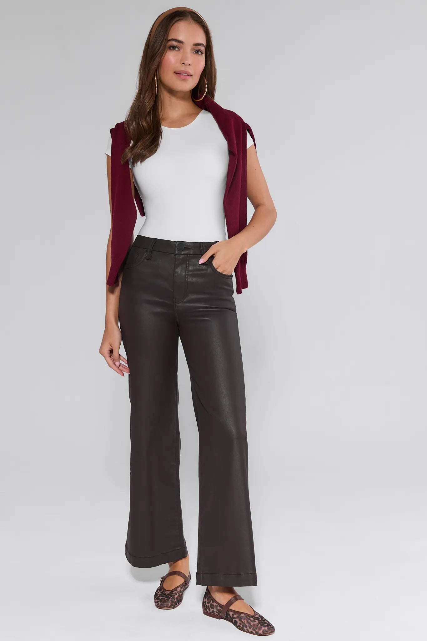 Woman wearing a white top, maroon cardigan, and brown Meg Jeans Wax Coated on a white background