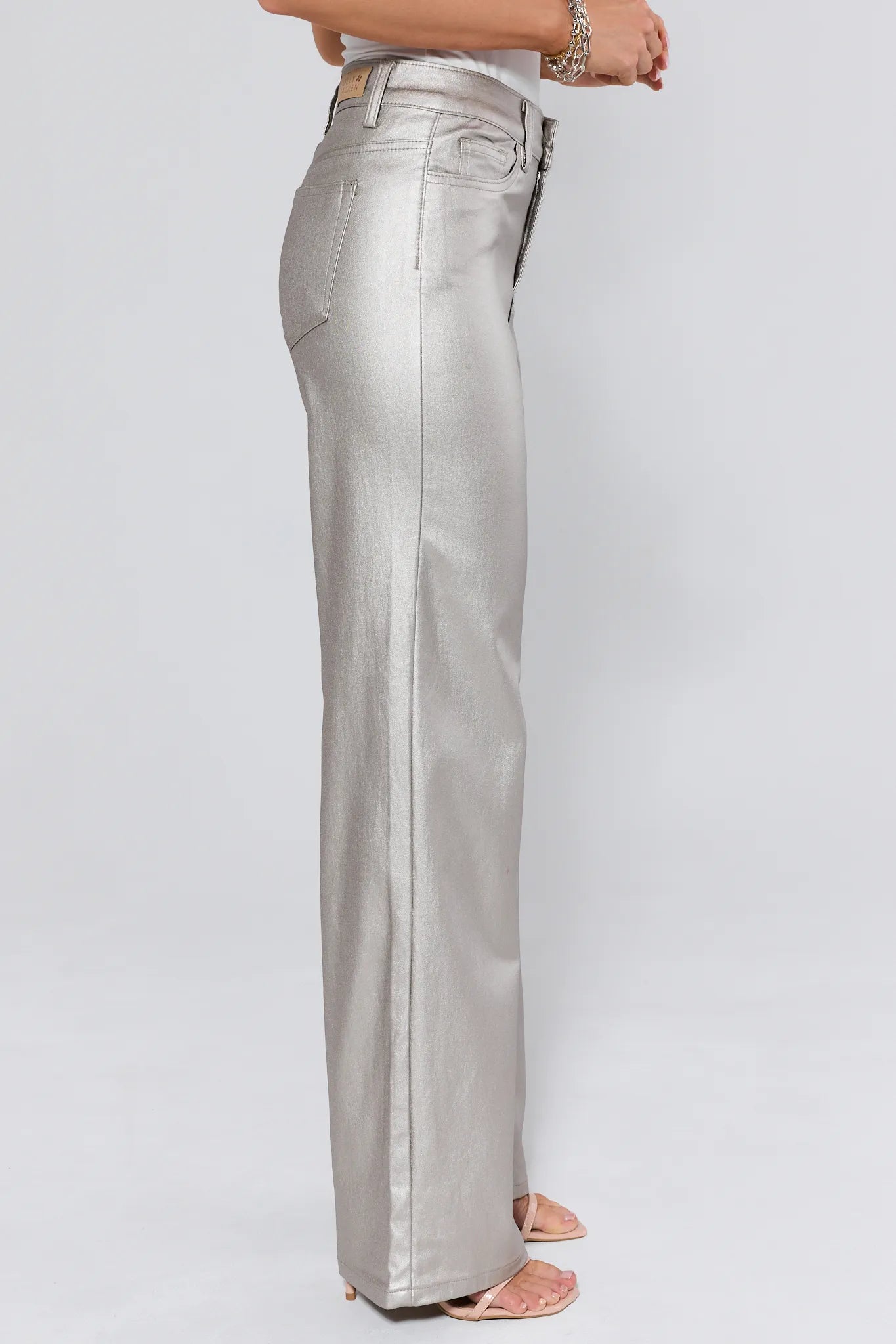 Silver metallic pants worn by a person on a white background