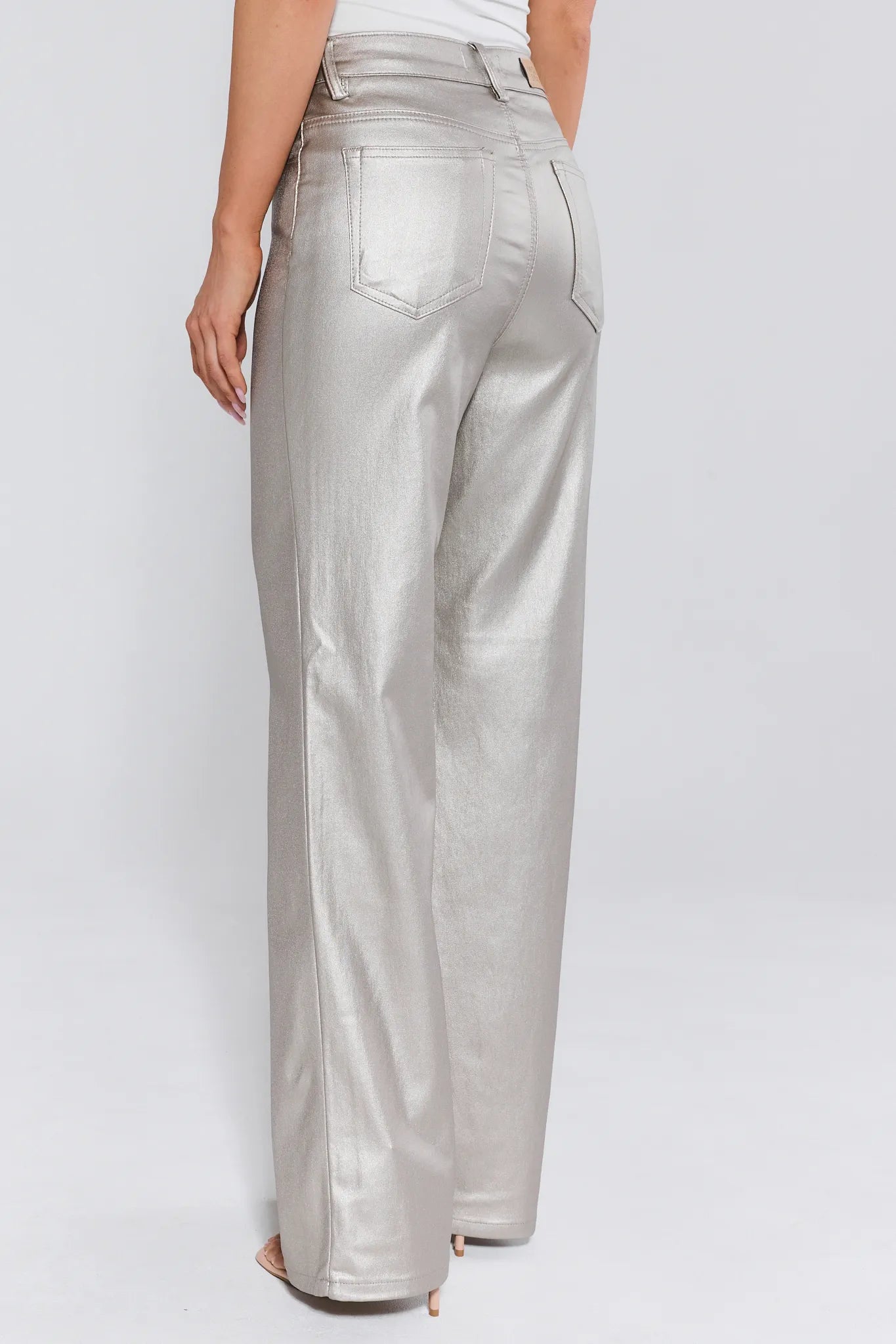 Silver pants worn by a person on a white background