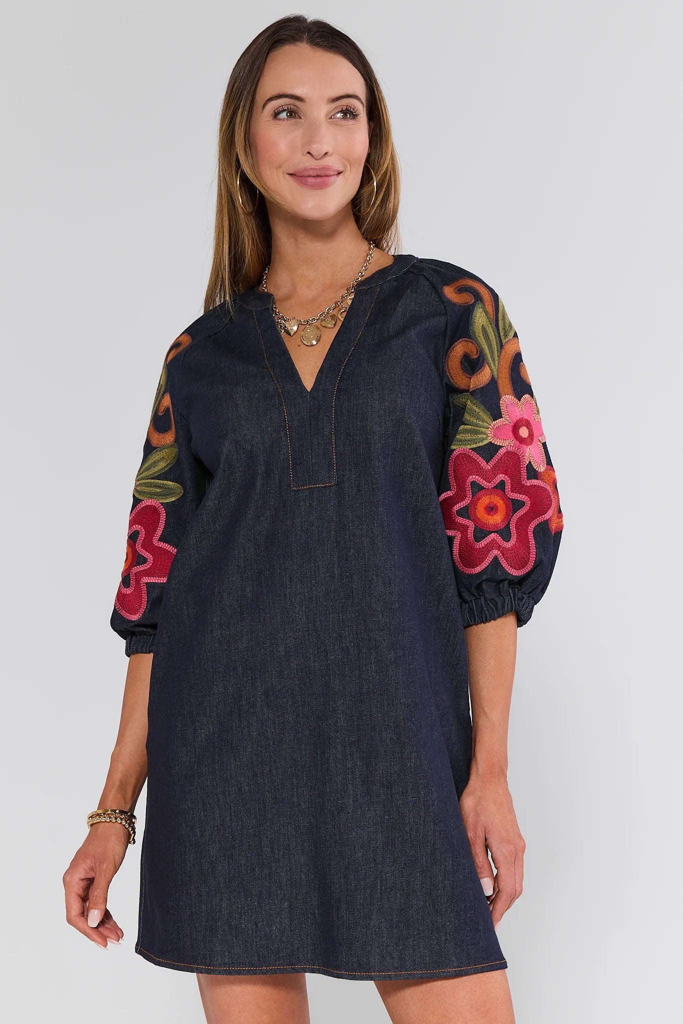 Woman wearing a navy Winnifred Dress with floral sleeves on a white background