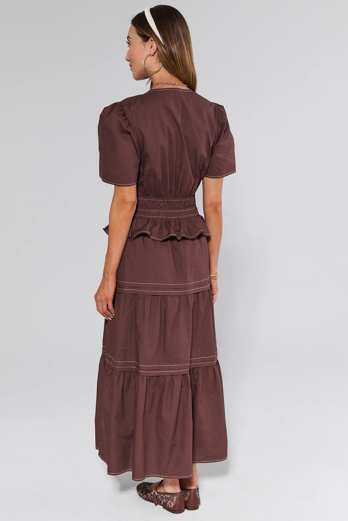 Woman wearing a brown Cherish Dress with a plain background