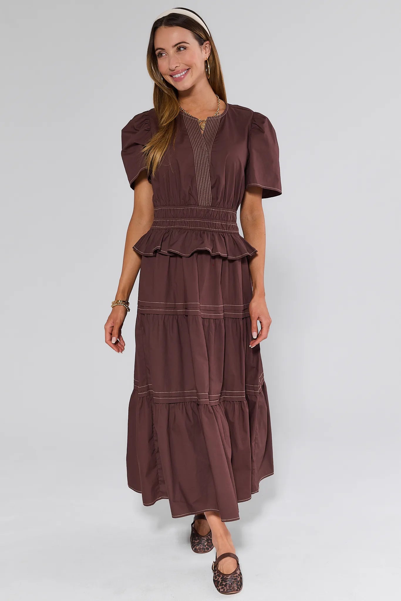 Woman wearing a brown Cherish Dress with a white background