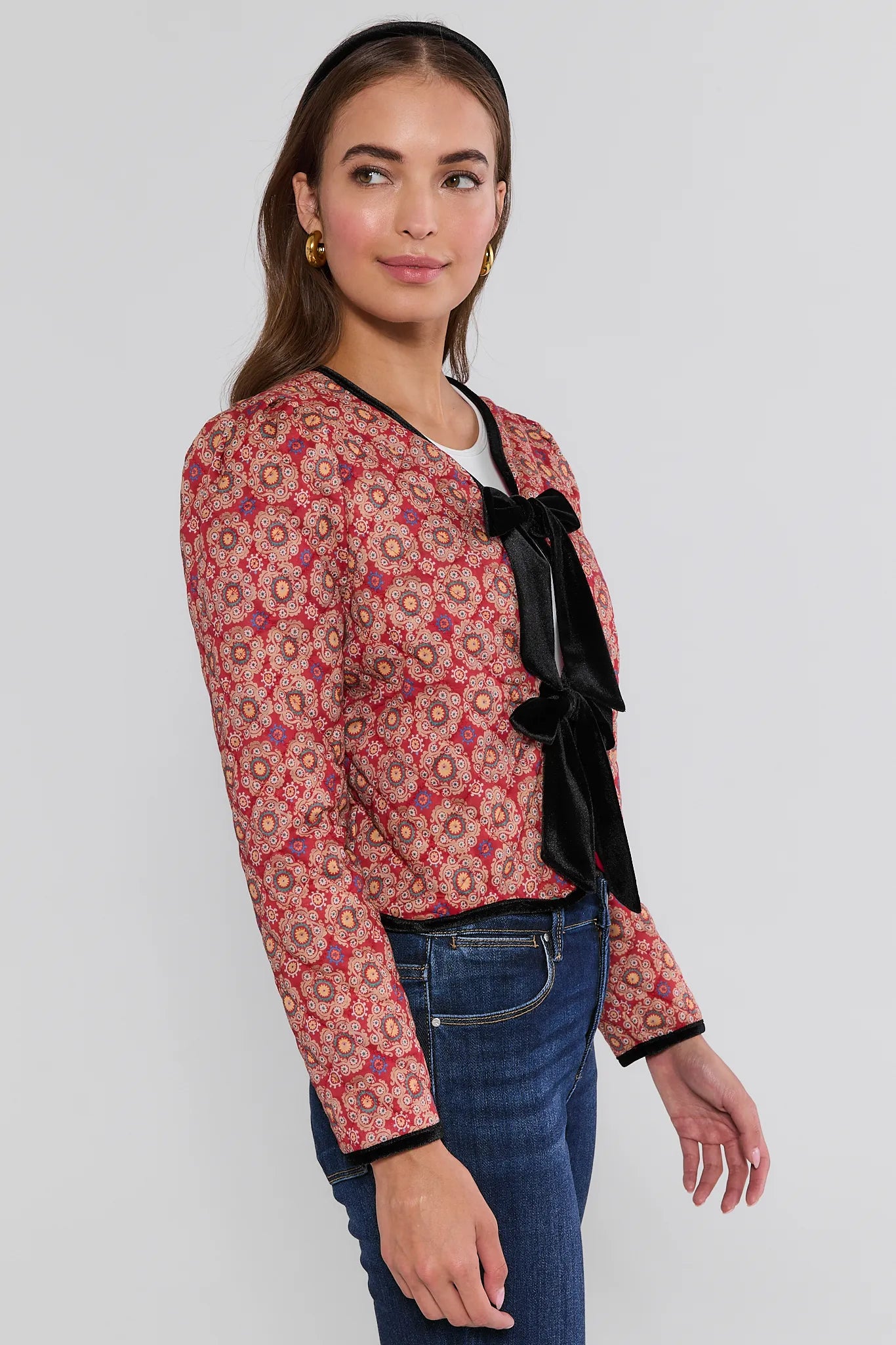 Woman wearing a red floral Ember Jacket with black trim on a white background