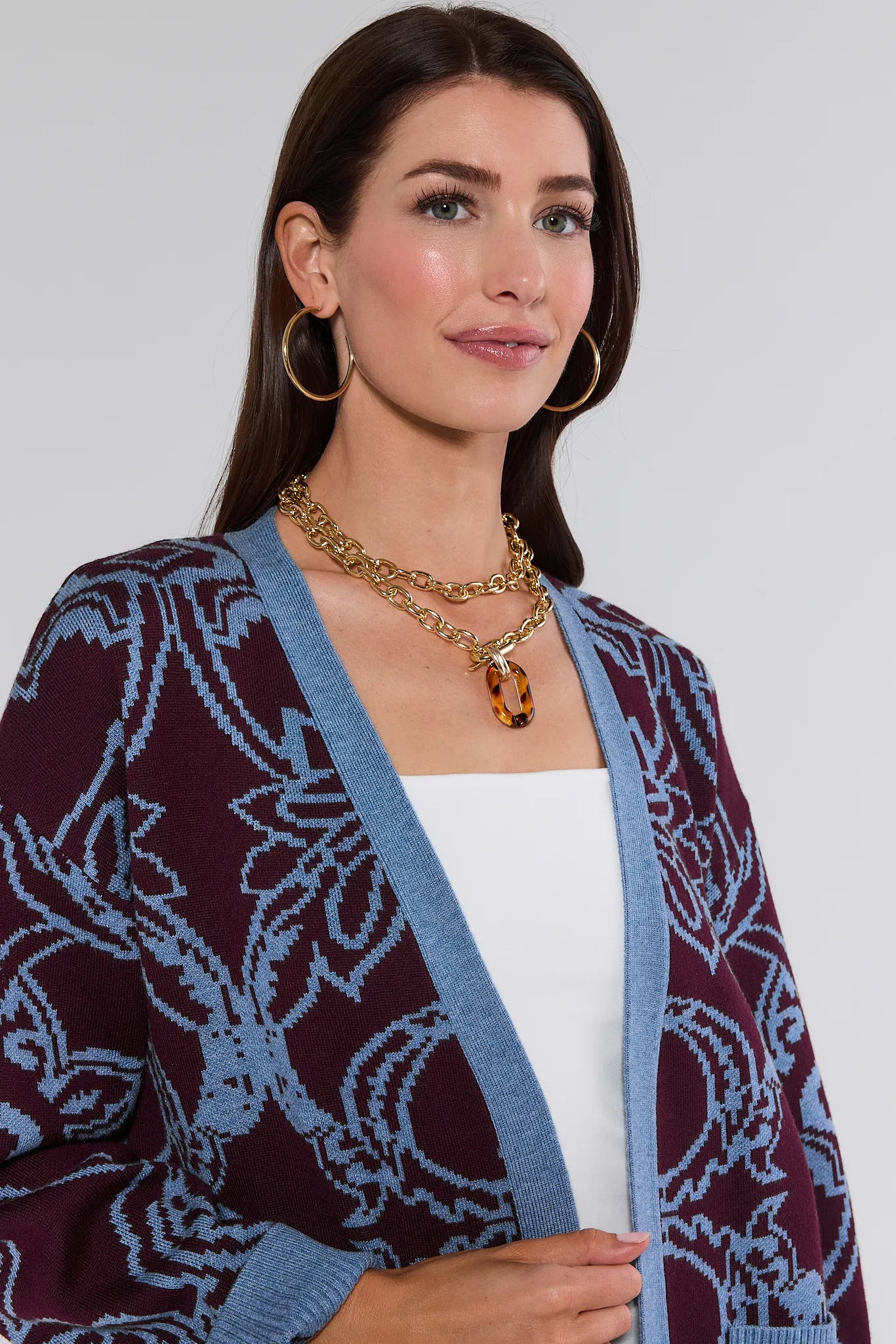 Woman wearing a patterned Liv Cardigan with a plain background