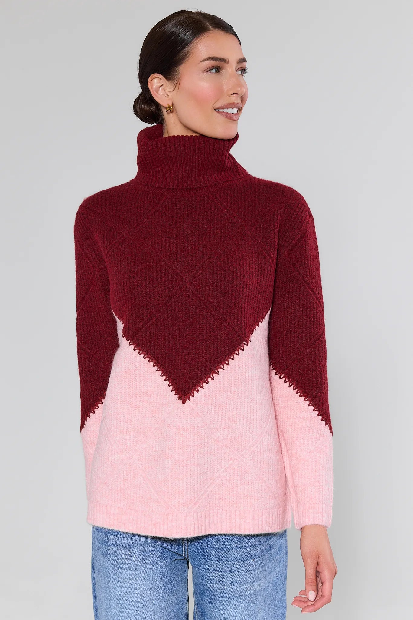 Woman wearing a Bianca Colorblock Turtleneck Sweater maroon and pink with a white background