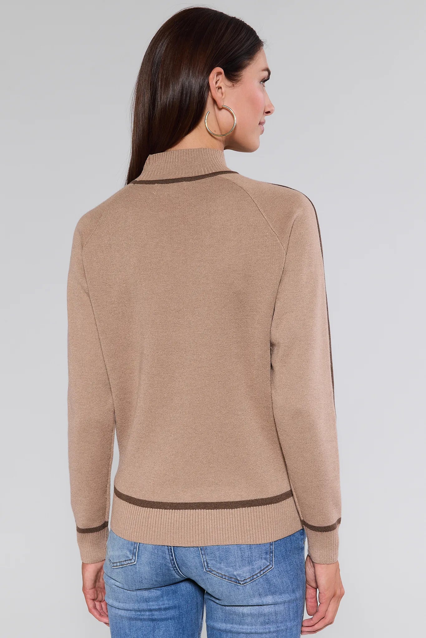 Woman wearing a beige Agnes Sweater
with a white background