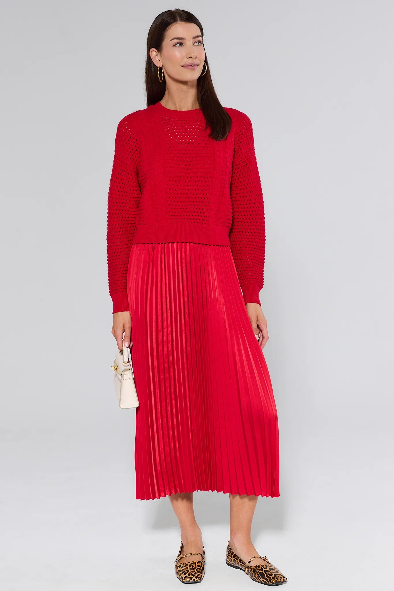 Woman wearing a red knitted and pleated gabbie dress against a white background