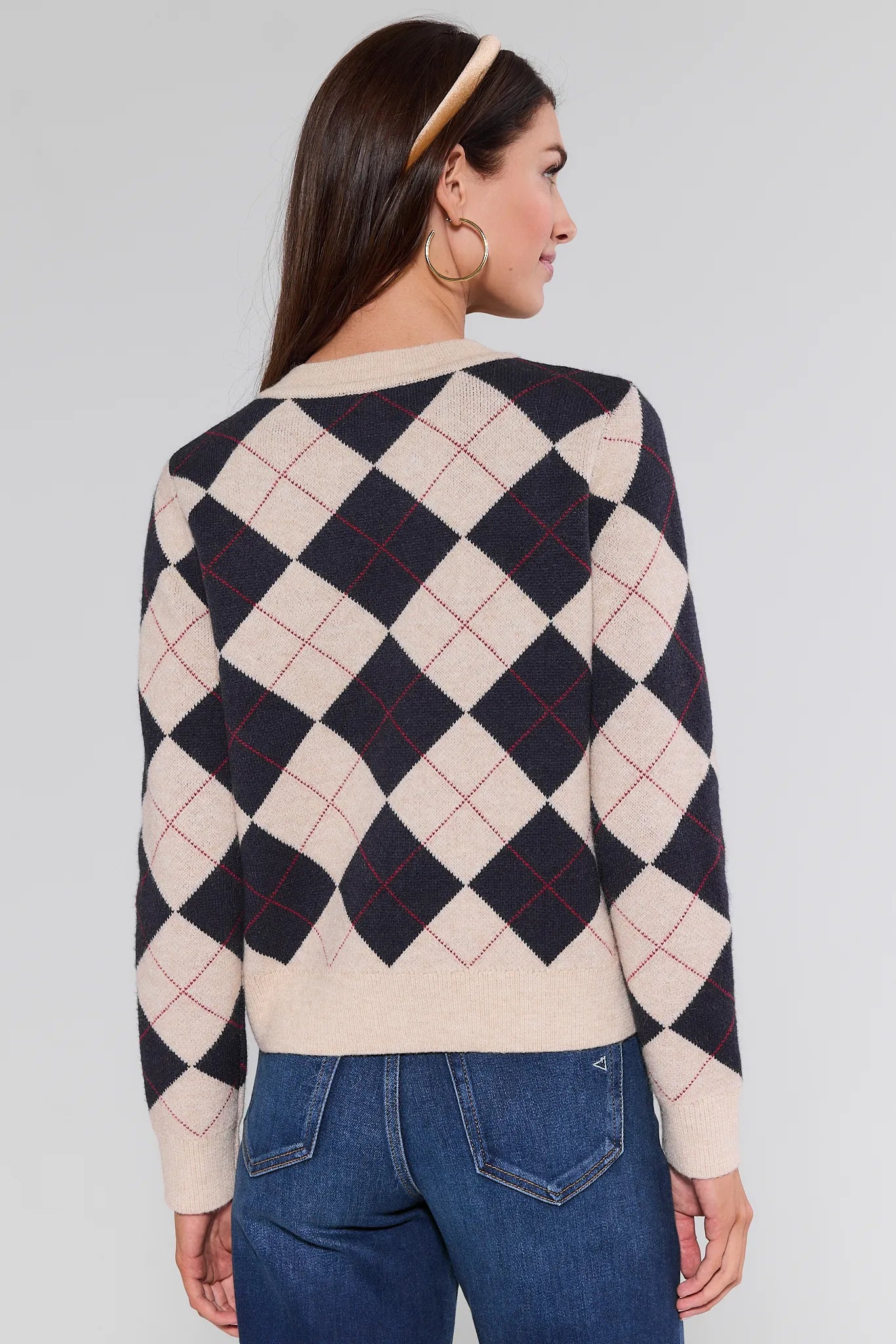 Woman wearing a patterned Winifred Sweater with a plain background