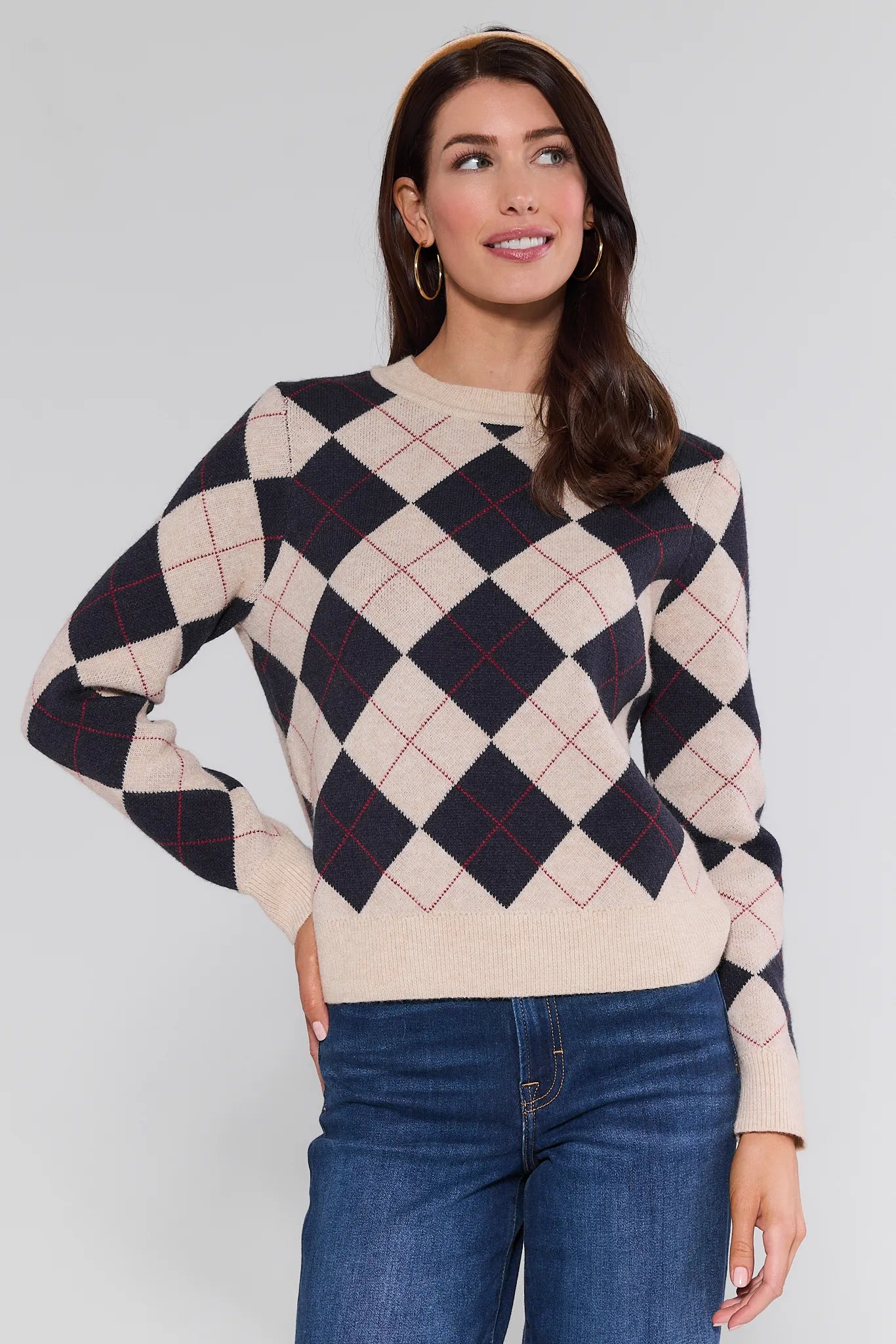Woman wearing a patterned Winifred Sweater and jeans against a plain background