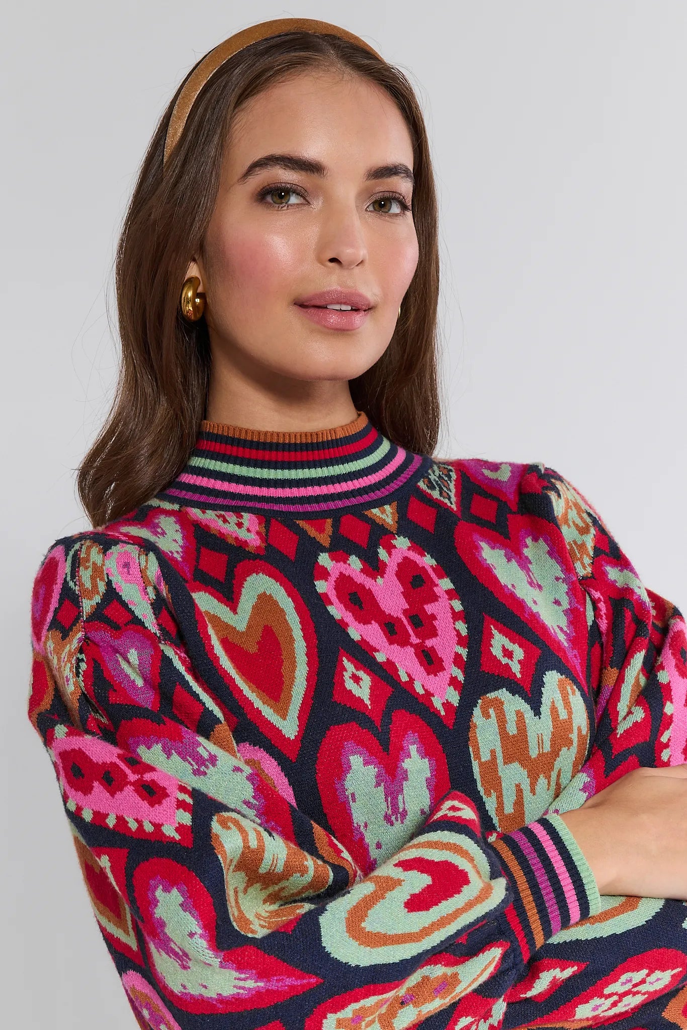 Woman wearing a colorful patterned Maddie sweater with a plain background