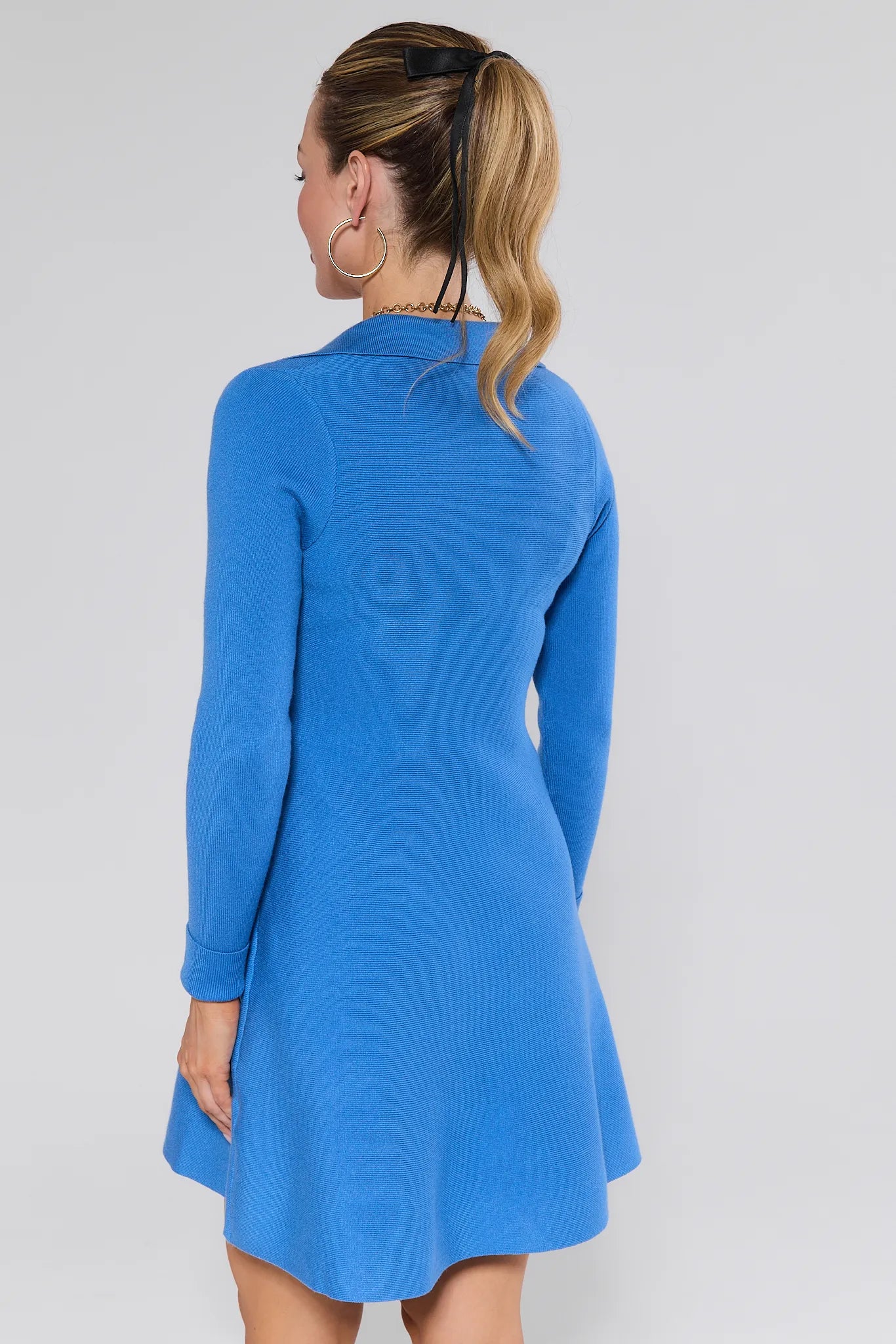 Woman wearing a blue Amelia Dress against a plain background