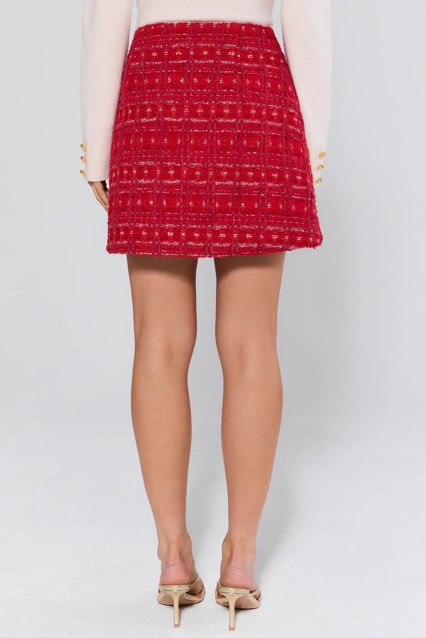 Red patterned skirt worn by a person on a white background