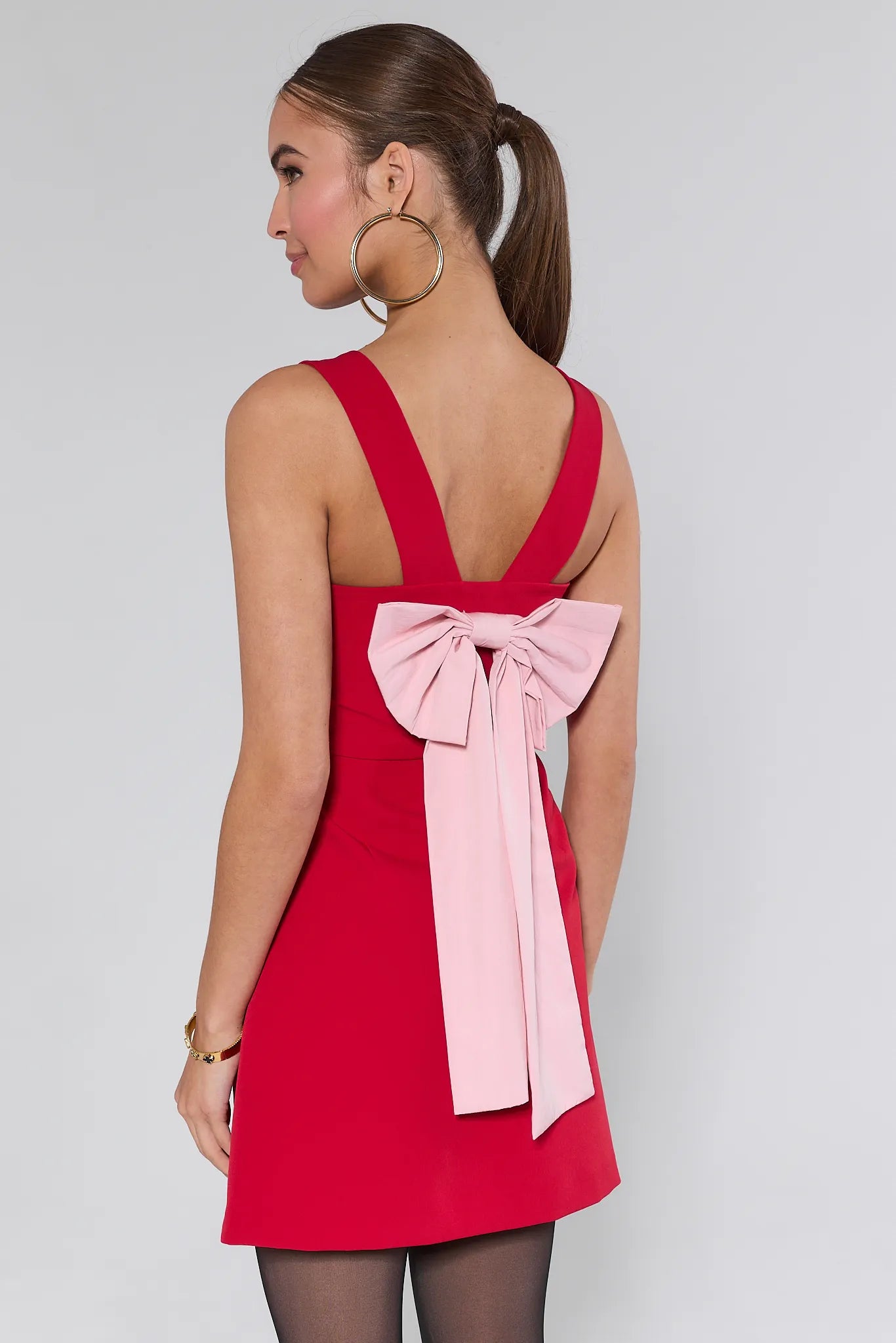 Woman wearing a red Nina dress against a plain background