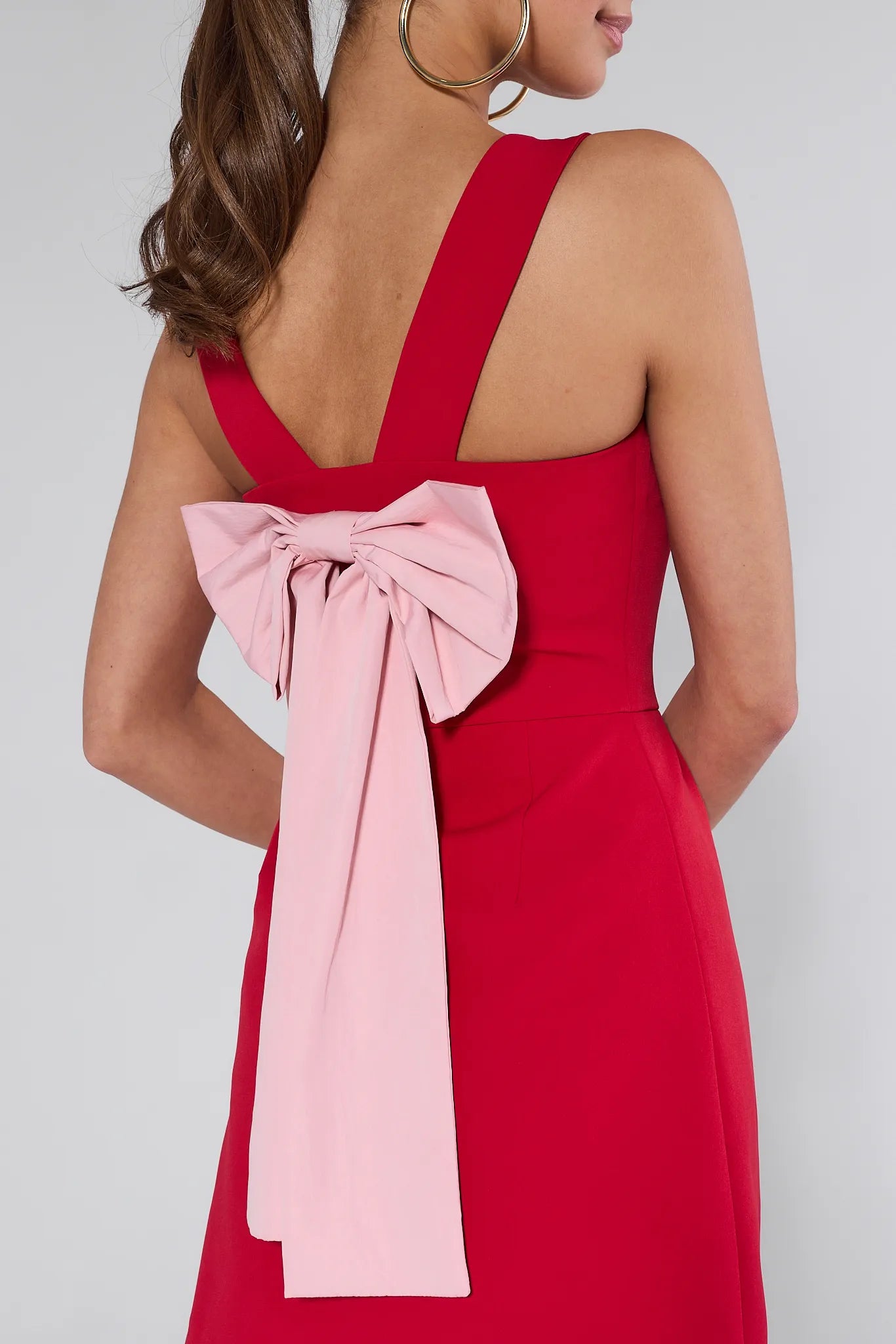 Woman wearing a red Nina dress against a plain background