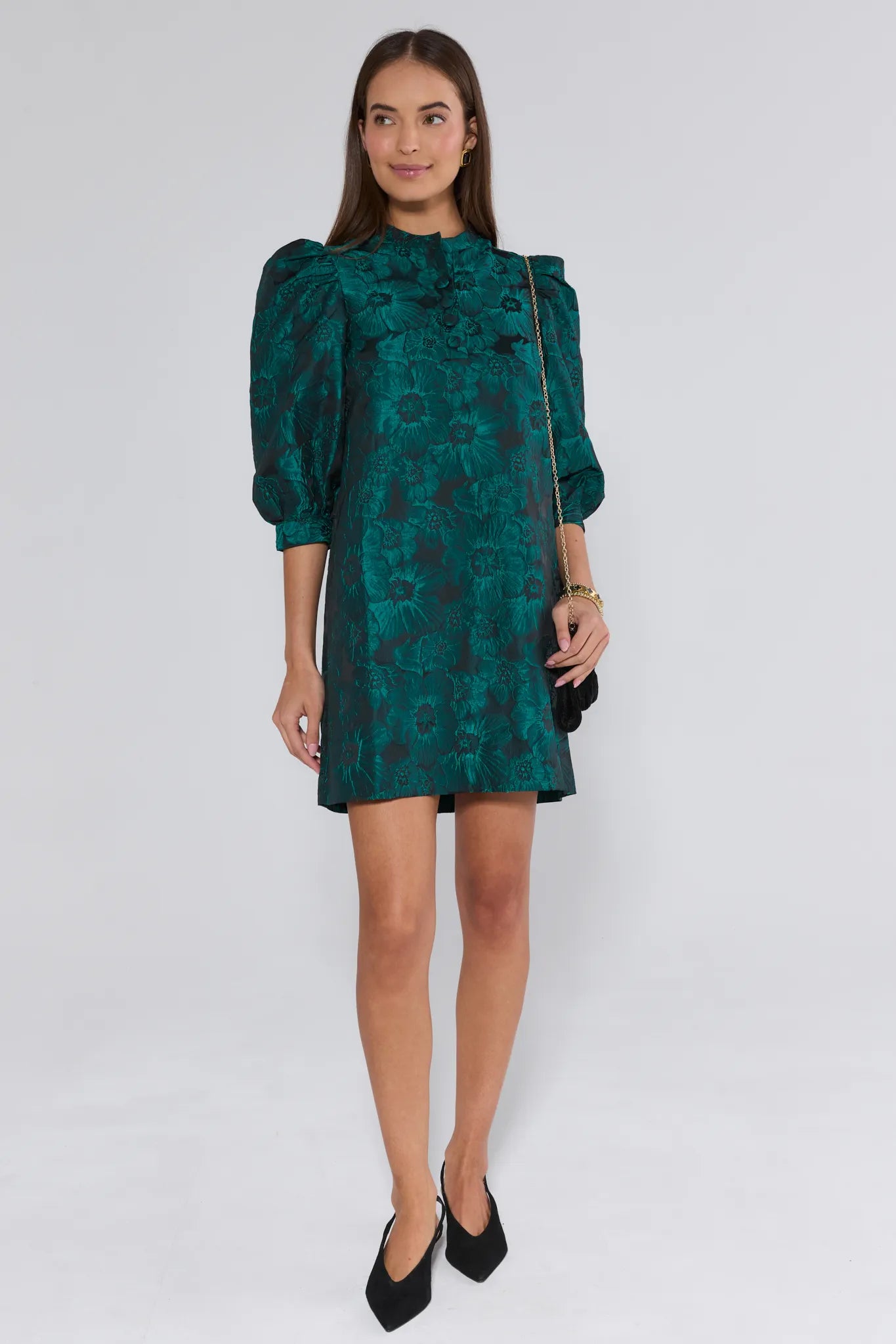 Woman wearing a green floral dress on a white background
