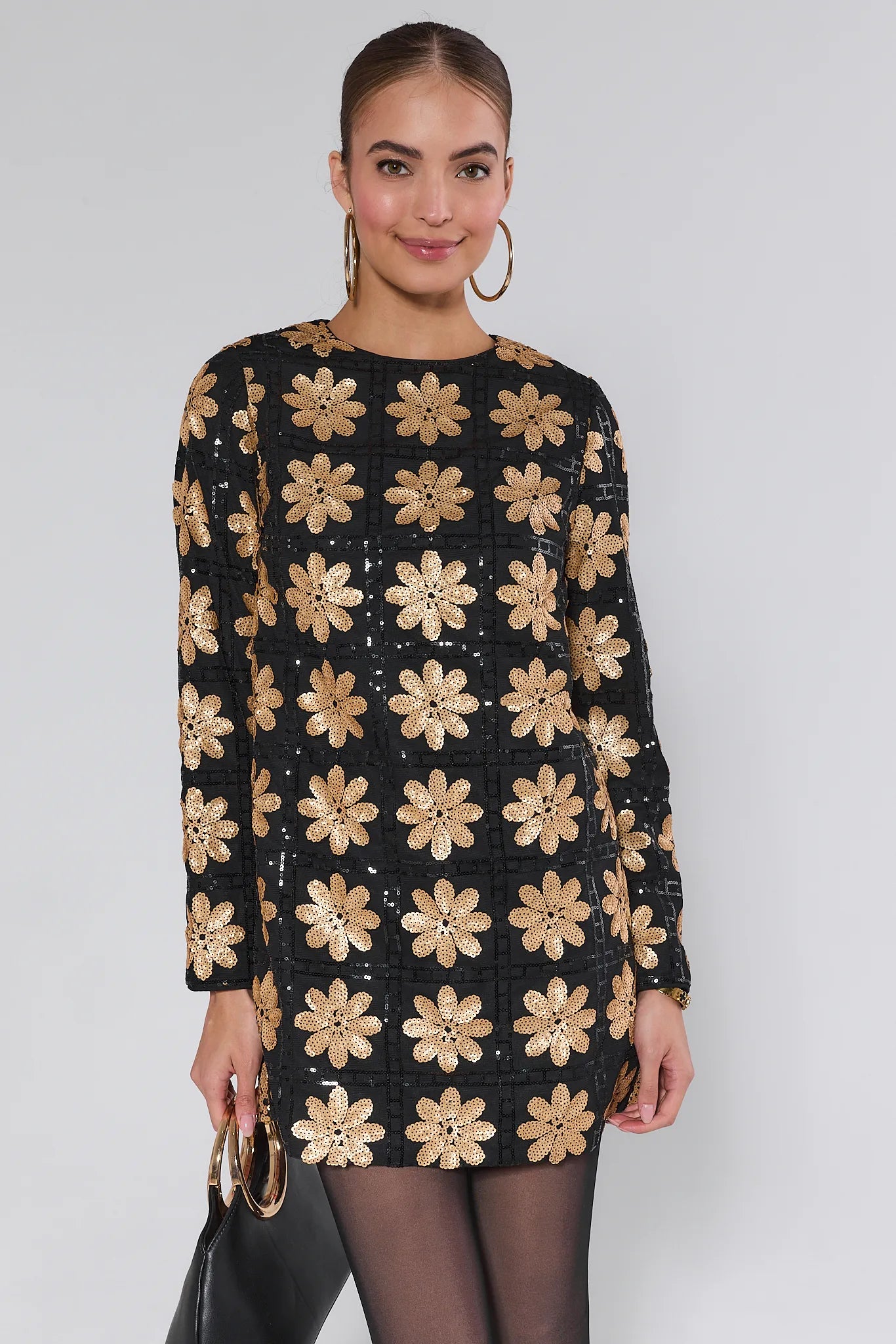 Woman wearing a Claudia Sequin Floral Mini Dress on a white background