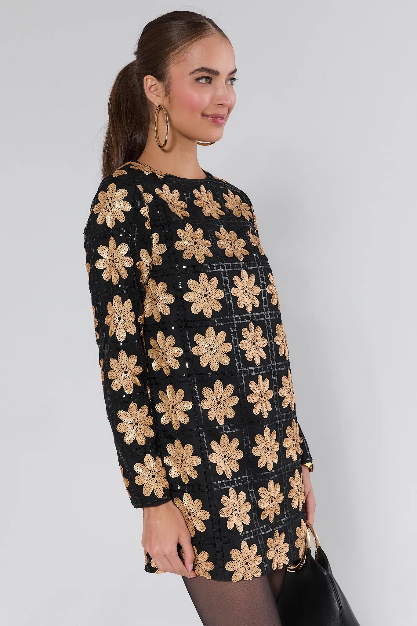 Woman wearing a Claudia Sequin Floral Mini Dress on a white background