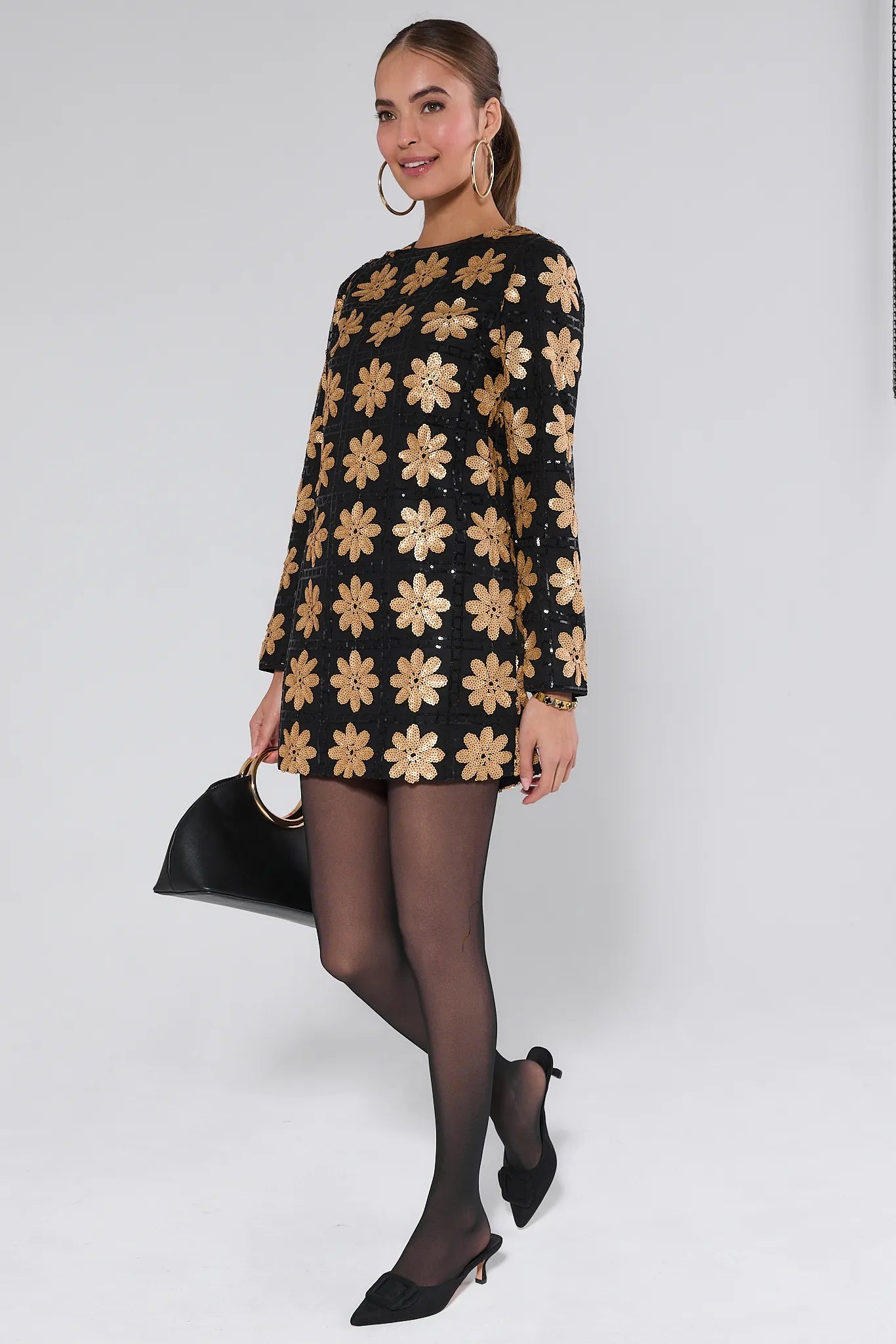 Woman wearing a Claudia Sequin Floral Mini Dress on a white background