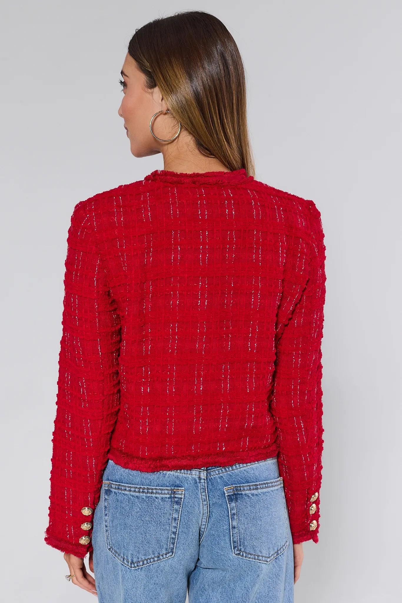Woman wearing a Evelyn Red Tweed Jacket with gold buttons on a plain background