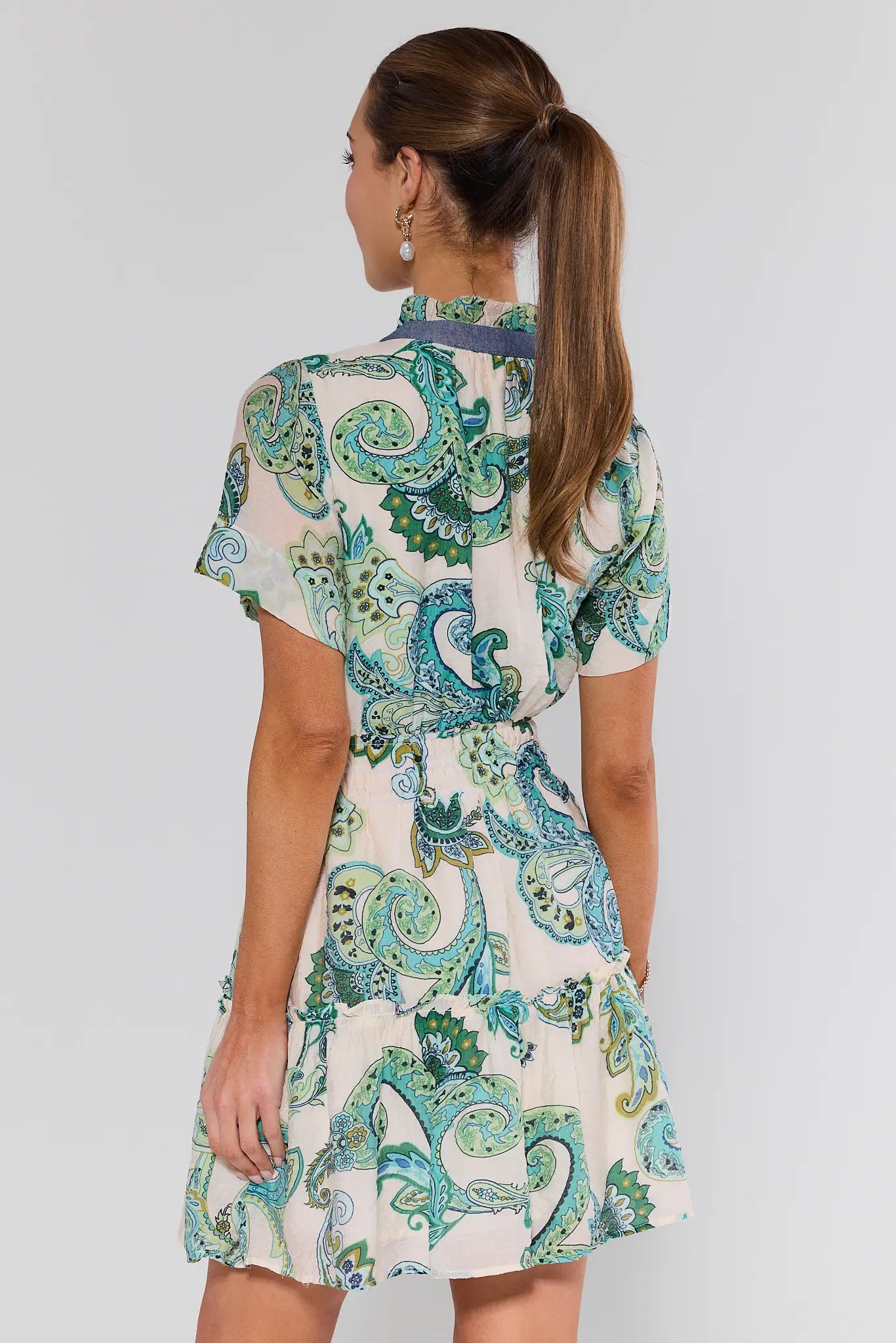 Woman wearing a patterned dress with a plain background
