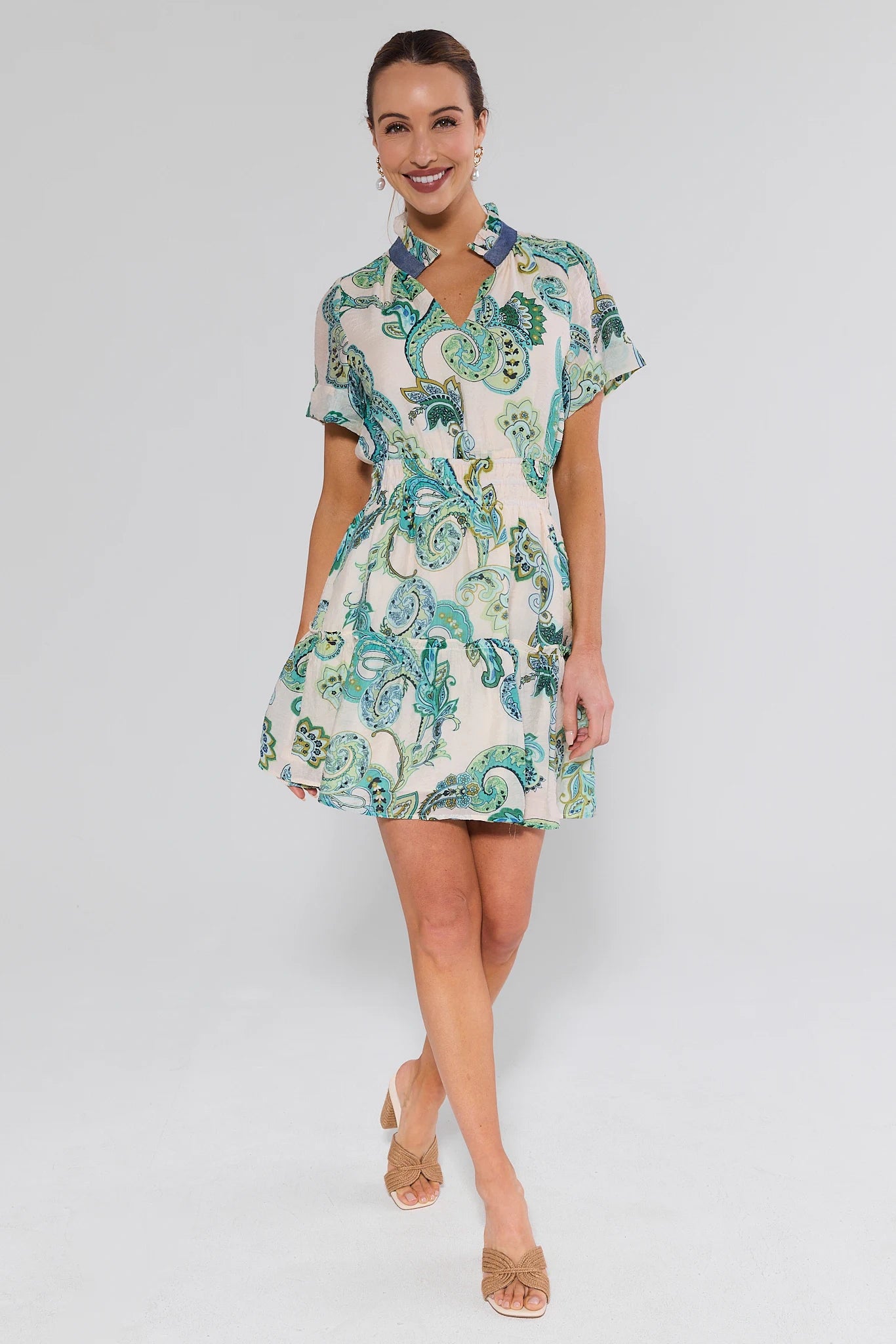 Woman wearing a patterned dress on a plain background