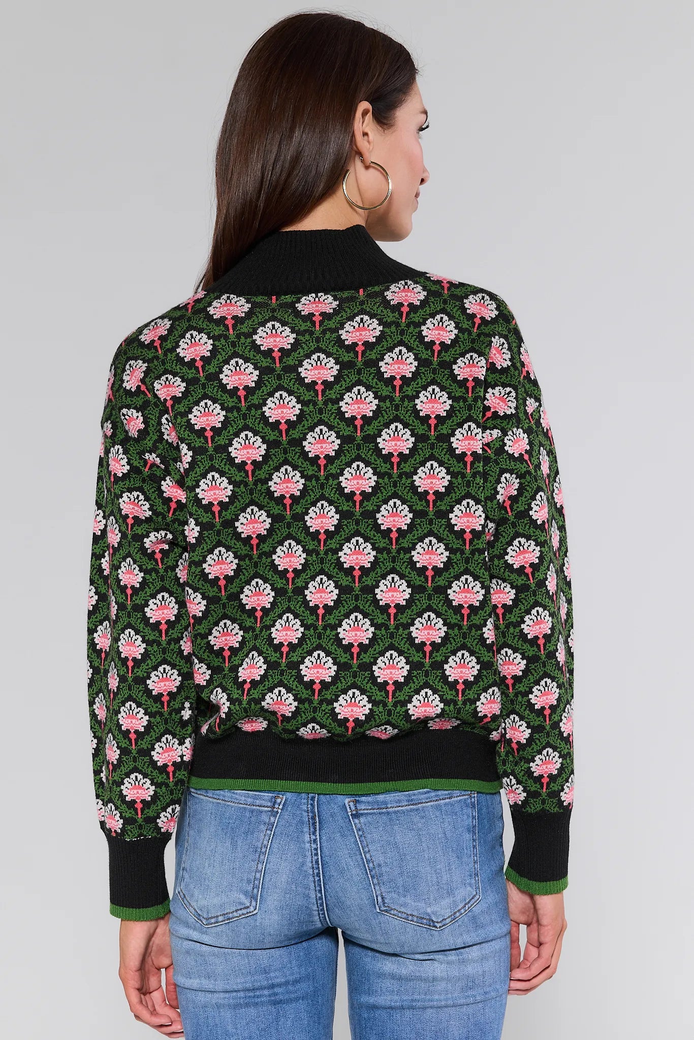Woman wearing a Janie Sweater a floral pattern on a plain background
