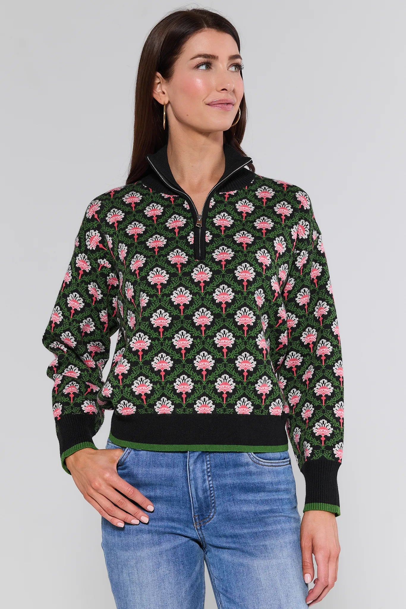 Woman wearing a floral patterned Janie Sweater with a plain background