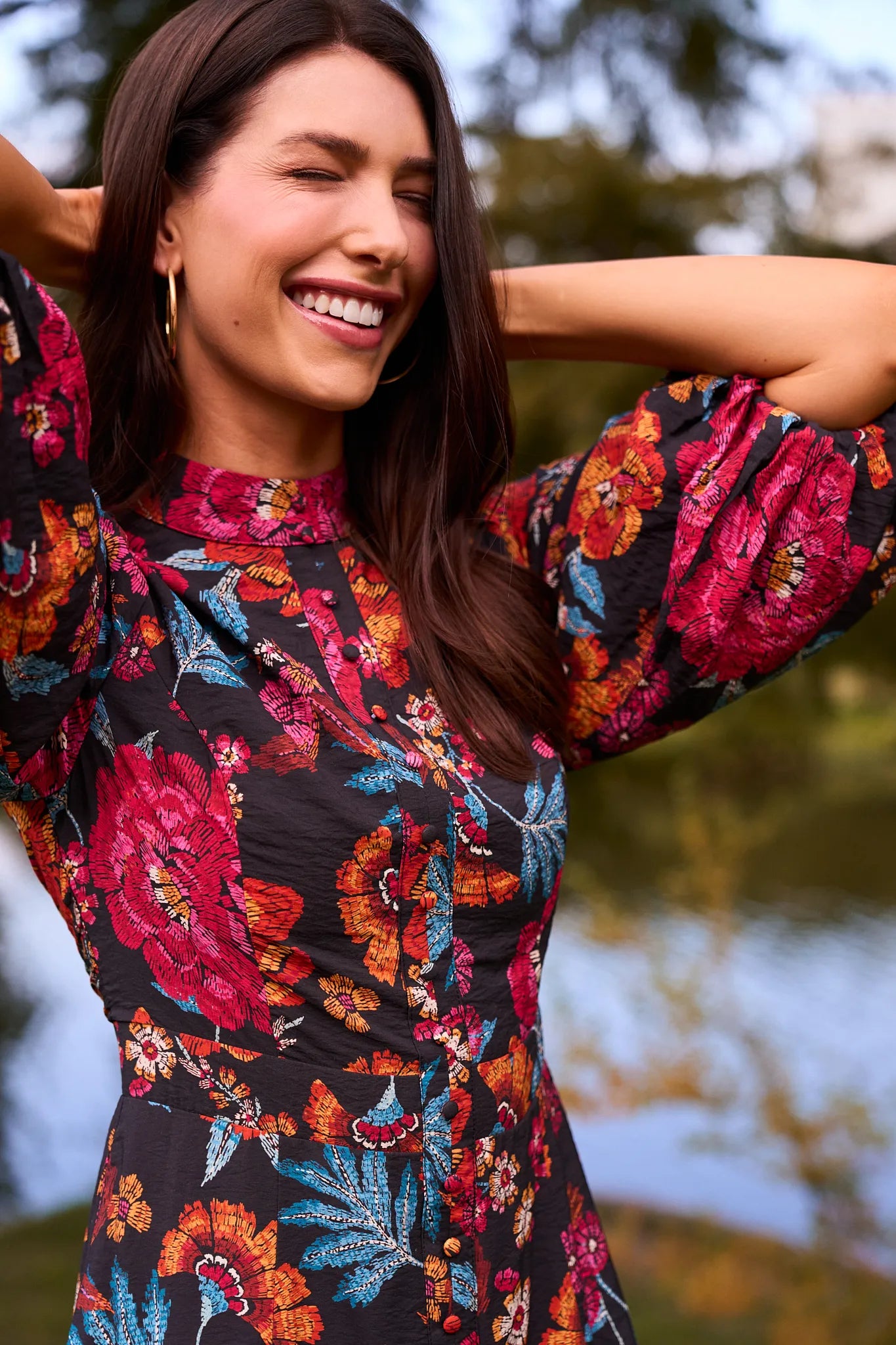 Woman wearing a colorful floral Desi Dress with a blurred natural background