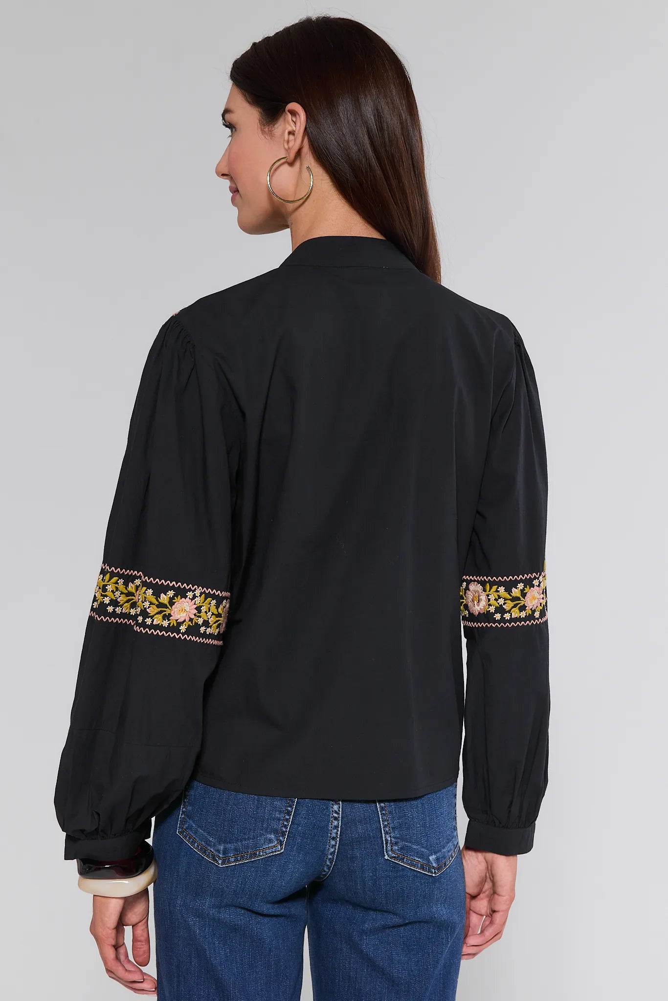 Black Selma Top with floral embroidery on sleeves worn by a person against a plain background