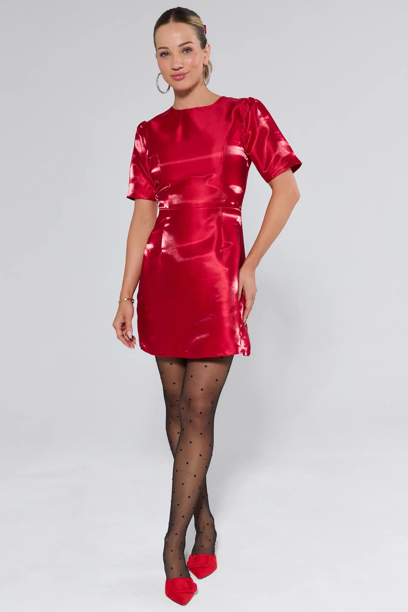 Woman wearing a red dress with puffed sleeves on a white background