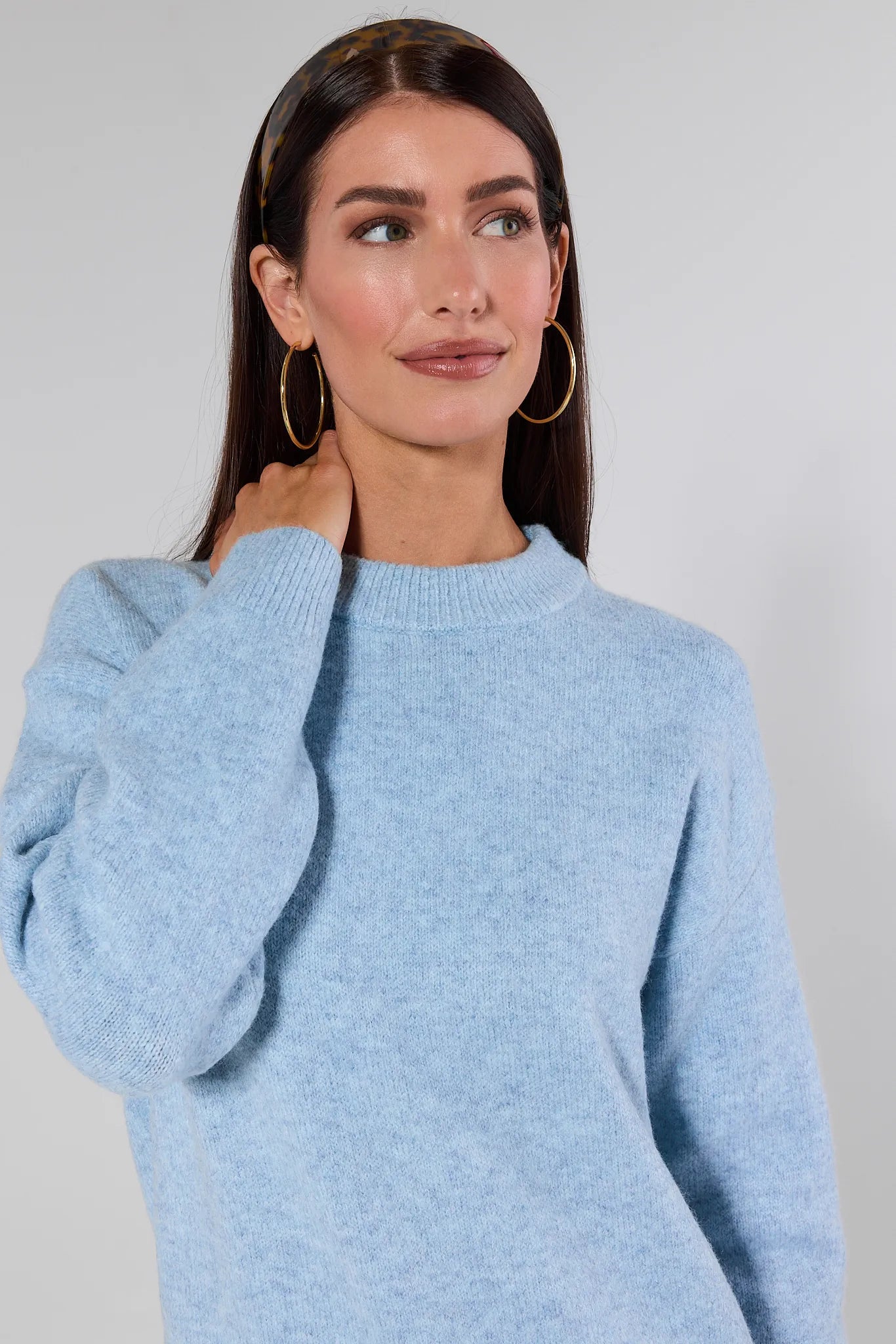 Woman wearing a Natalie Sweater and jeans against a plain background