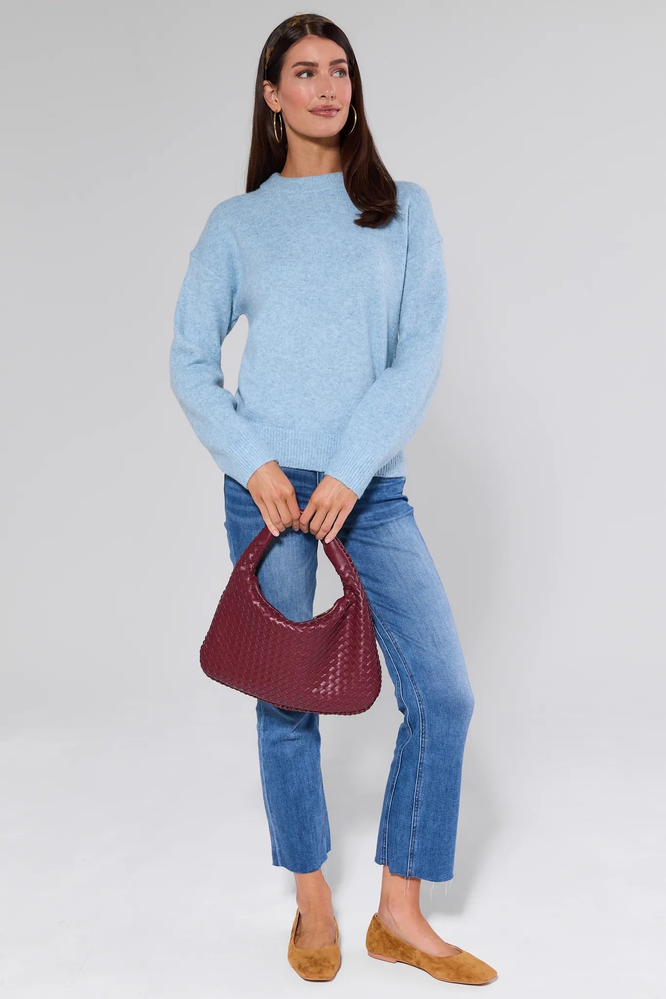 Woman wearing a Natalie Sweater and jeans against a plain background