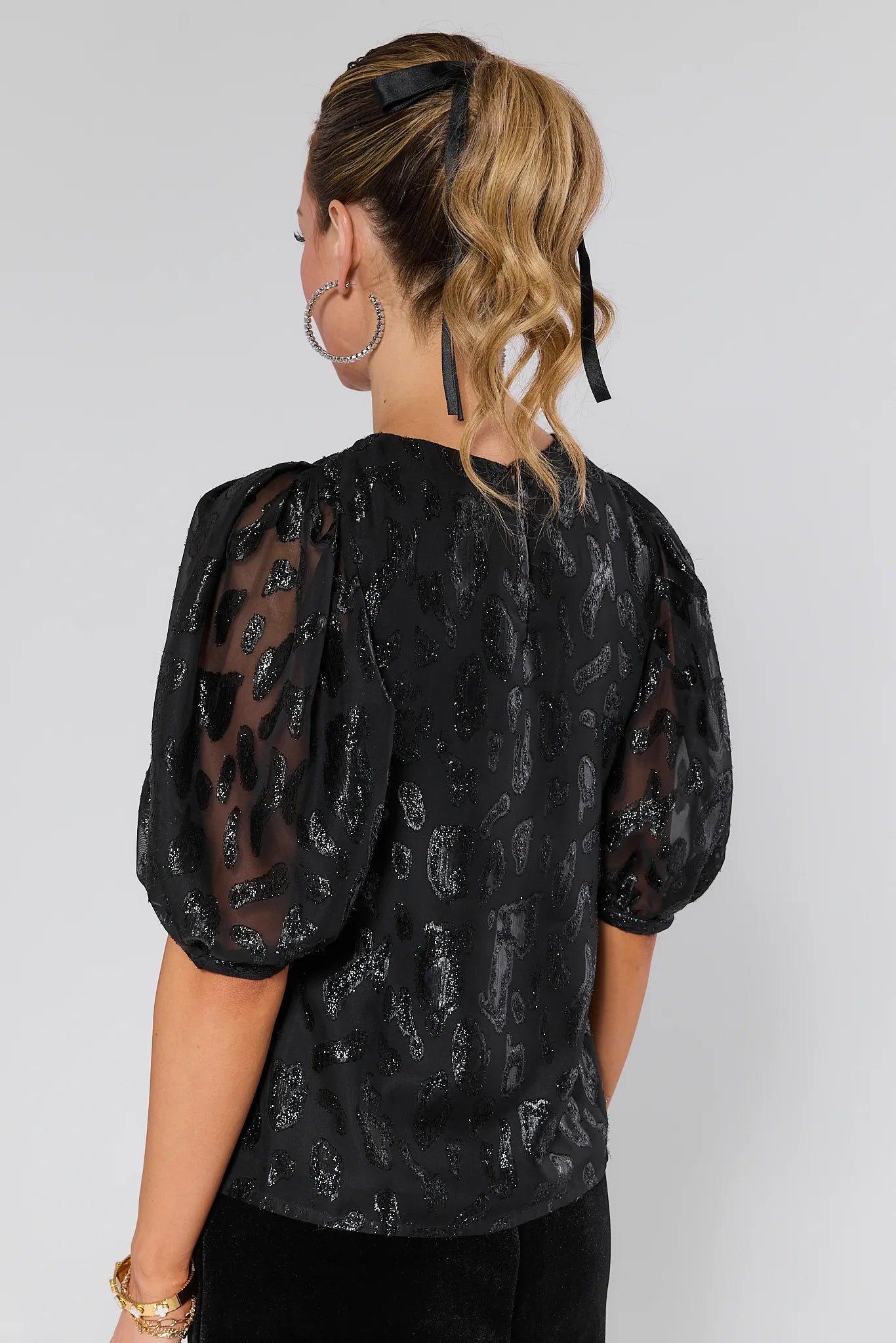 Woman wearing a Rebecca Metallic Leopard Print Top on a white background