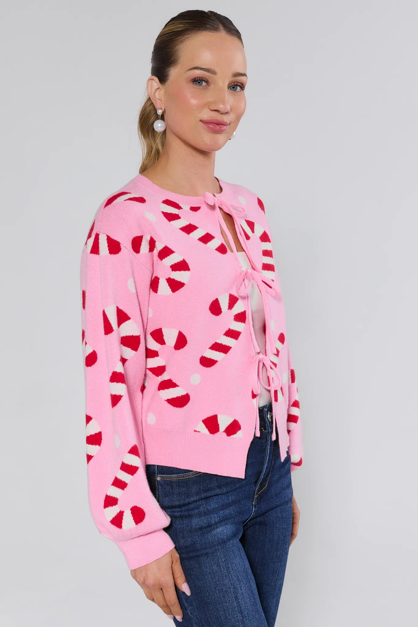 Woman wearing a Hollis Pink Candy Cane Sweater on a plain background