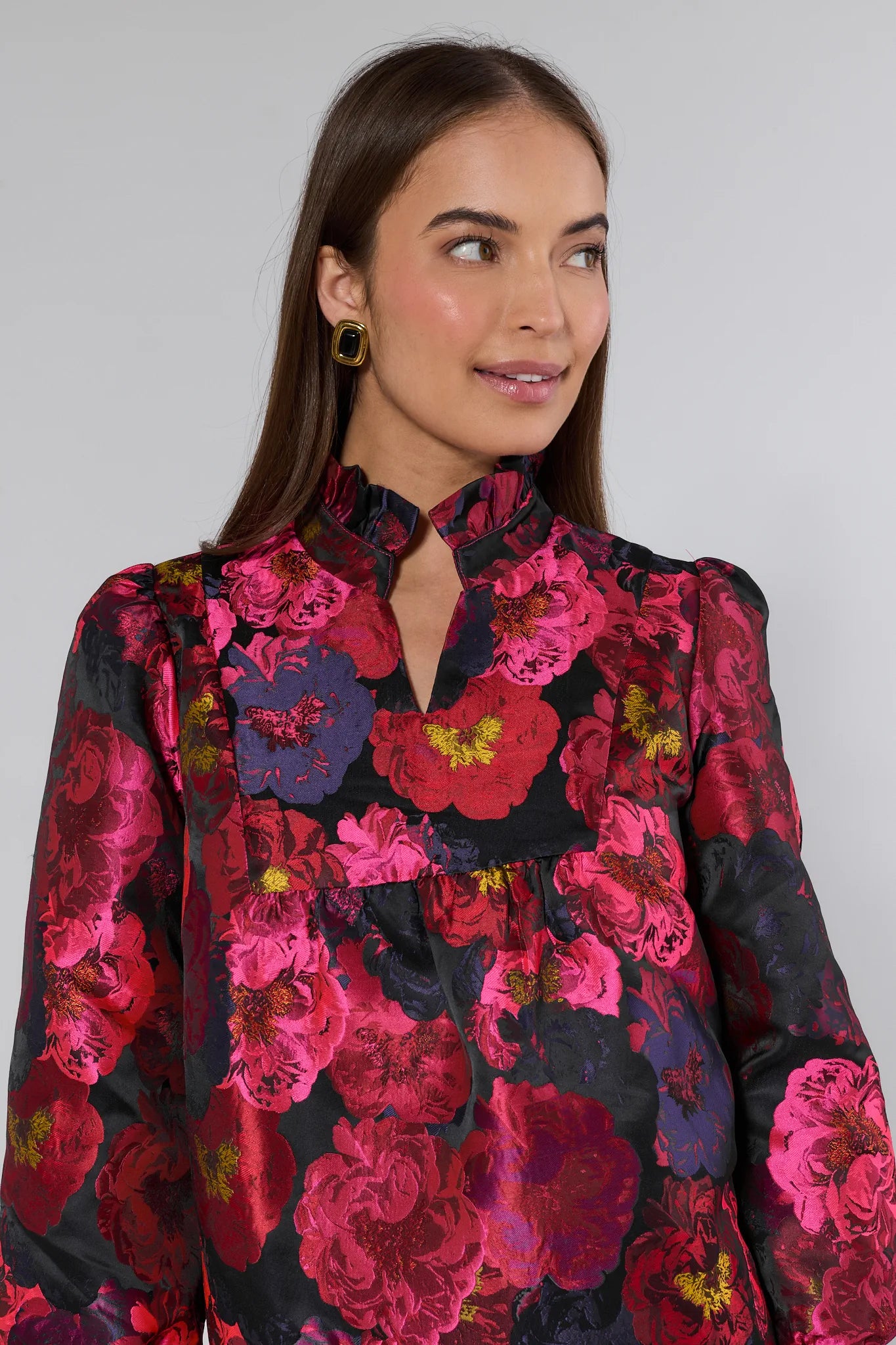 Woman wearing a floral ruby dress with a black background
