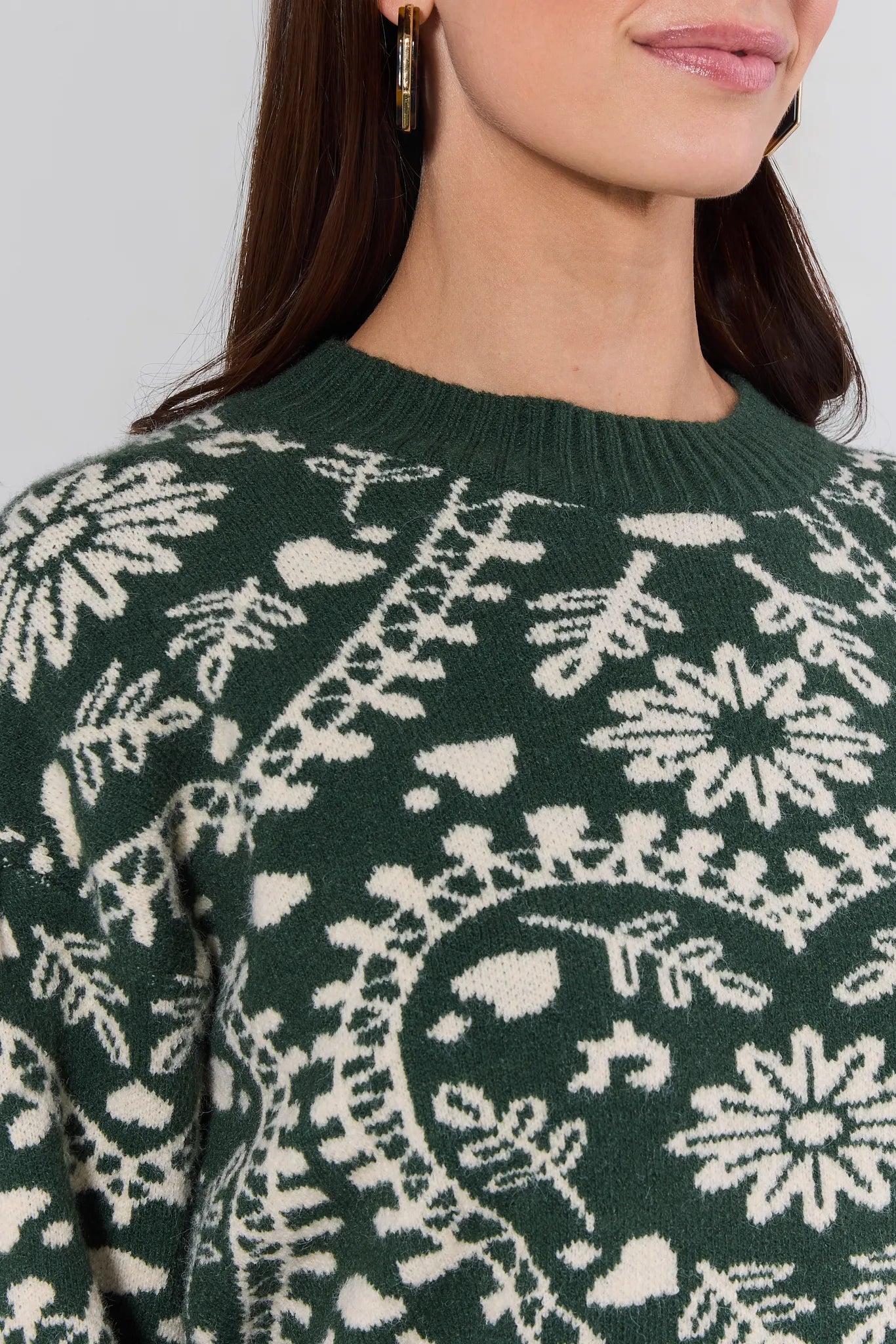 Close-up of a person wearing a green Pamela Sweater with white pattern