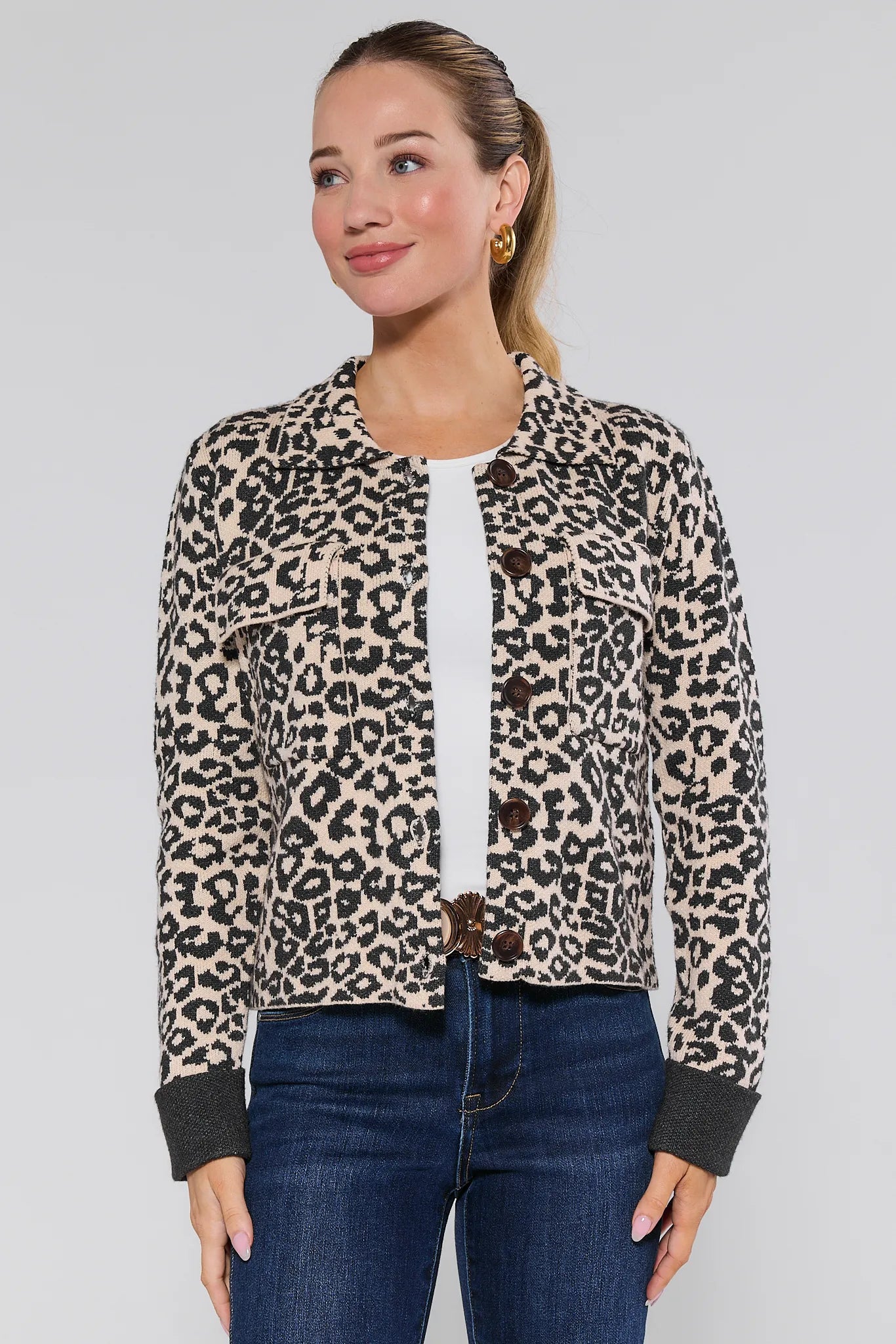 Woman wearing a leopard print Molly Jacket and blue jeans on a plain background