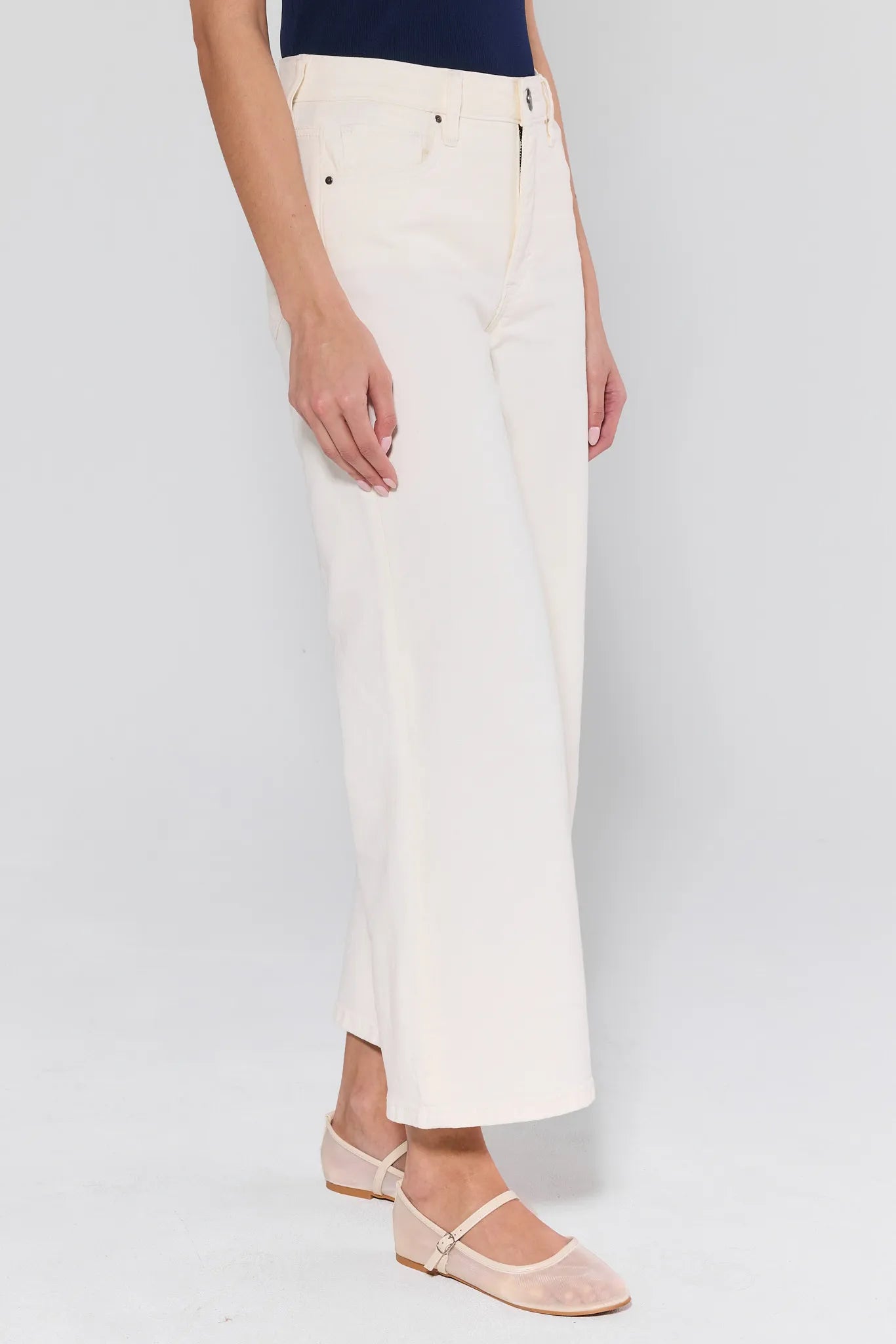 Model wearing Meg Cream Wide Leg Jeans, high-waisted with structured denim, paired with nude Mary-Jane flats, showcasing a chic, casual style.