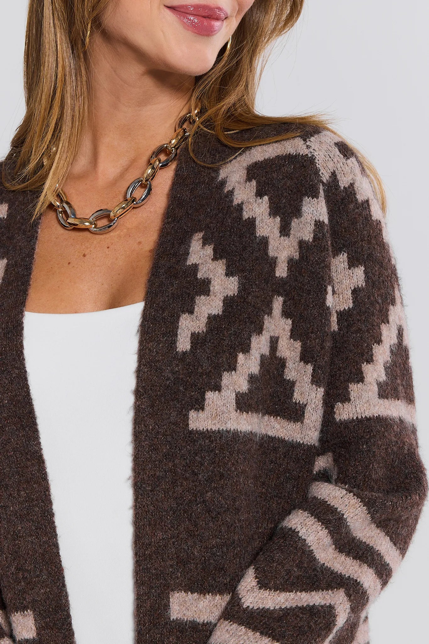 Person wearing a brown and beige patterned Helena Cardigan on a white background