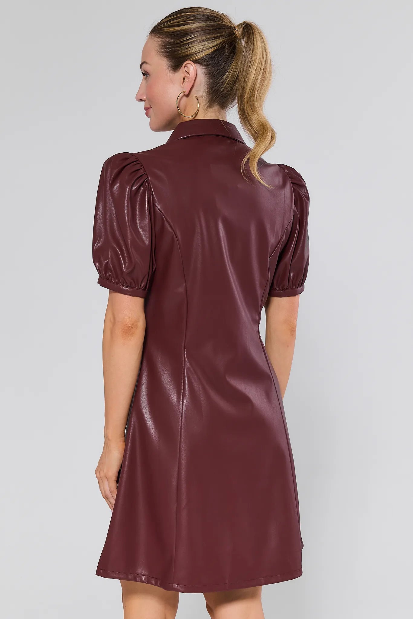 Woman wearing a burgundy leather Harley Dress against a white background