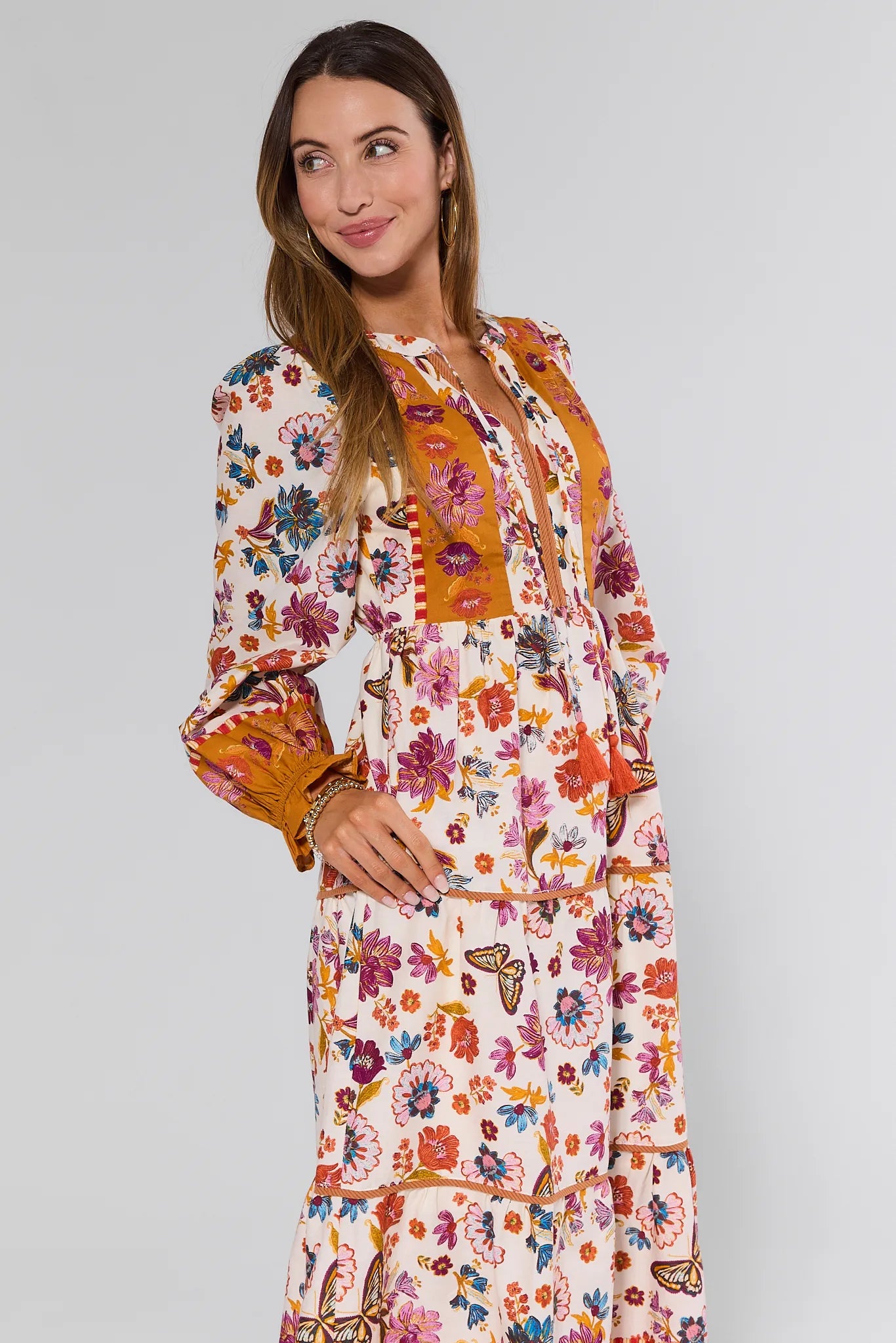 Woman wearing a floral Shiloh Dress with a plain background