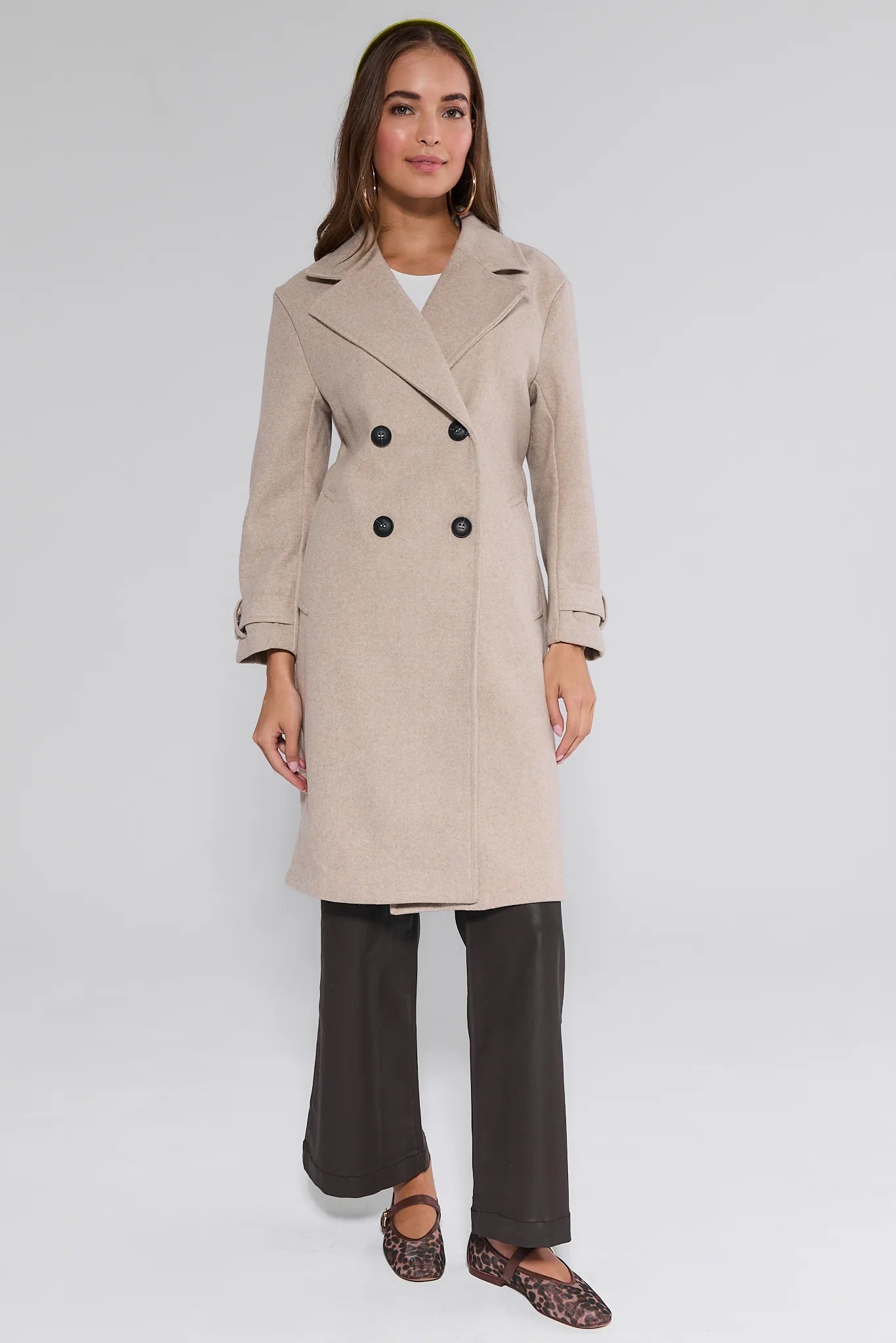 Woman wearing a beige trench Sadie Coat on a white background
