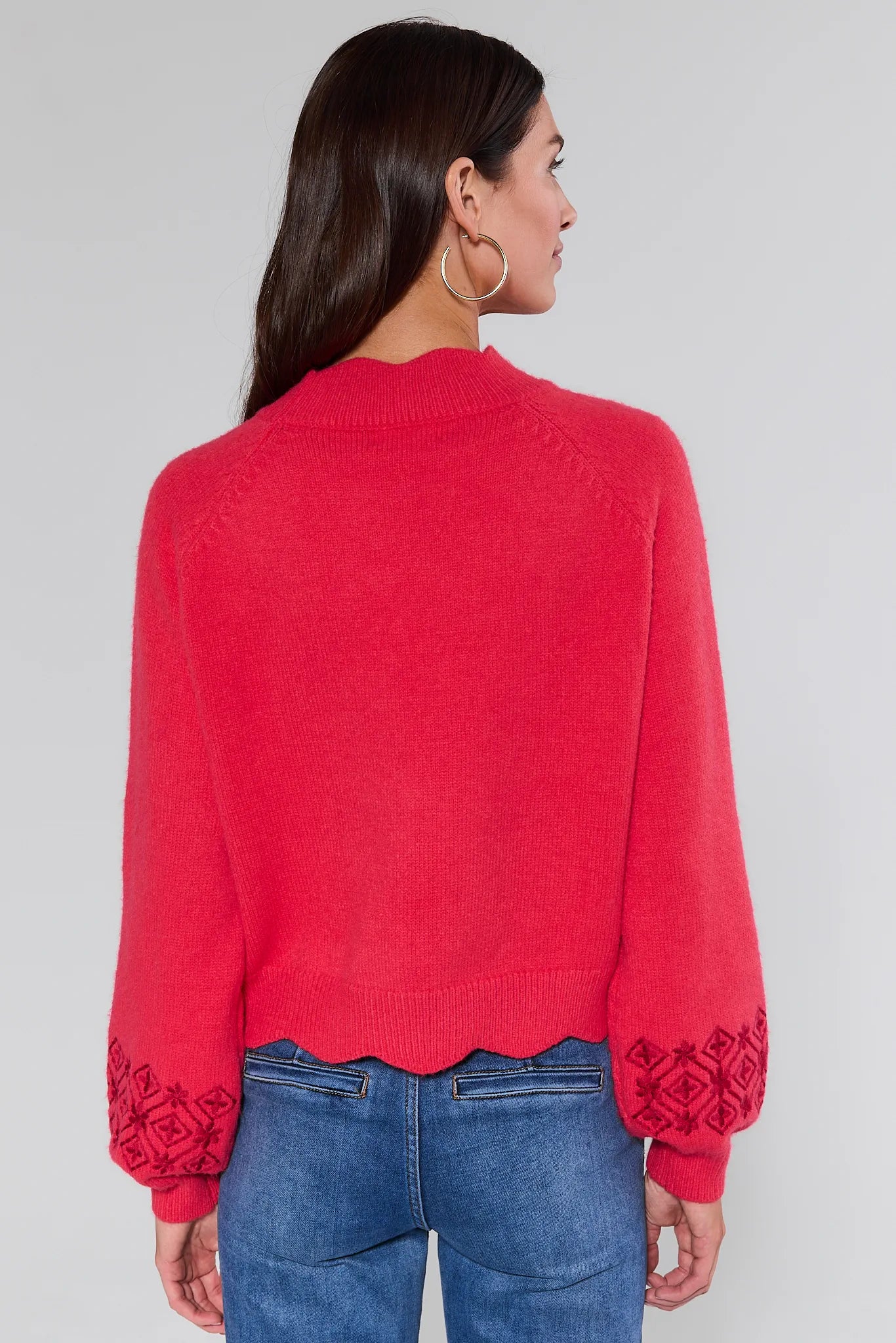 Woman wearing a Candace Red Embroidered Sweater on a plain background