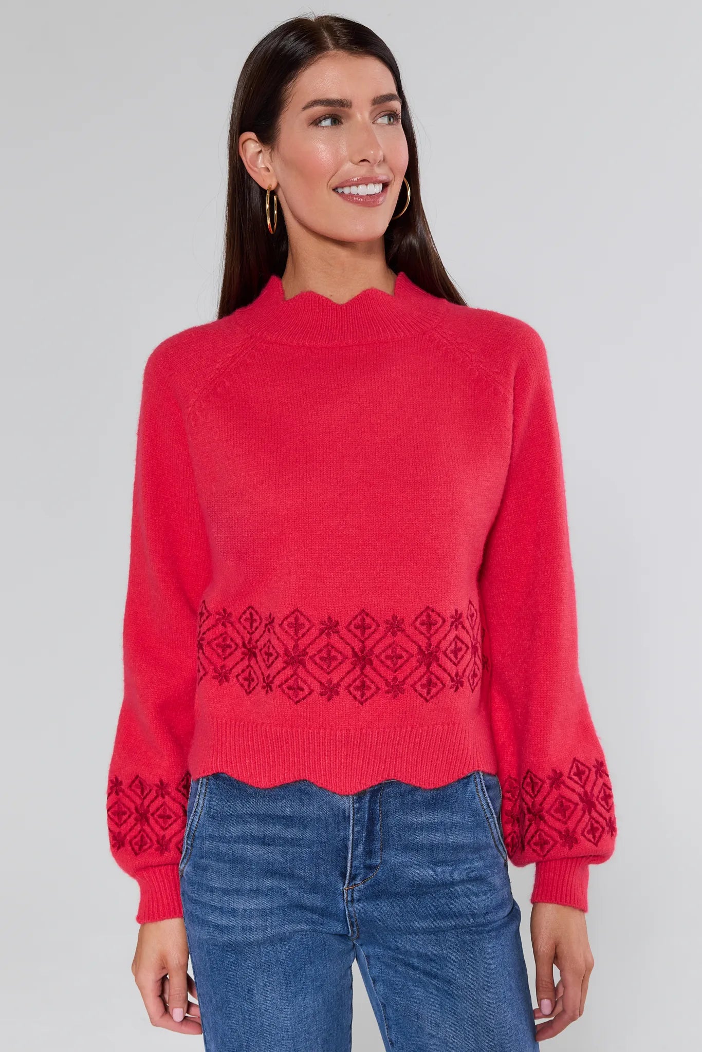 Woman wearing a Candace Red Embroidered Sweater with a patterned hem against a plain background